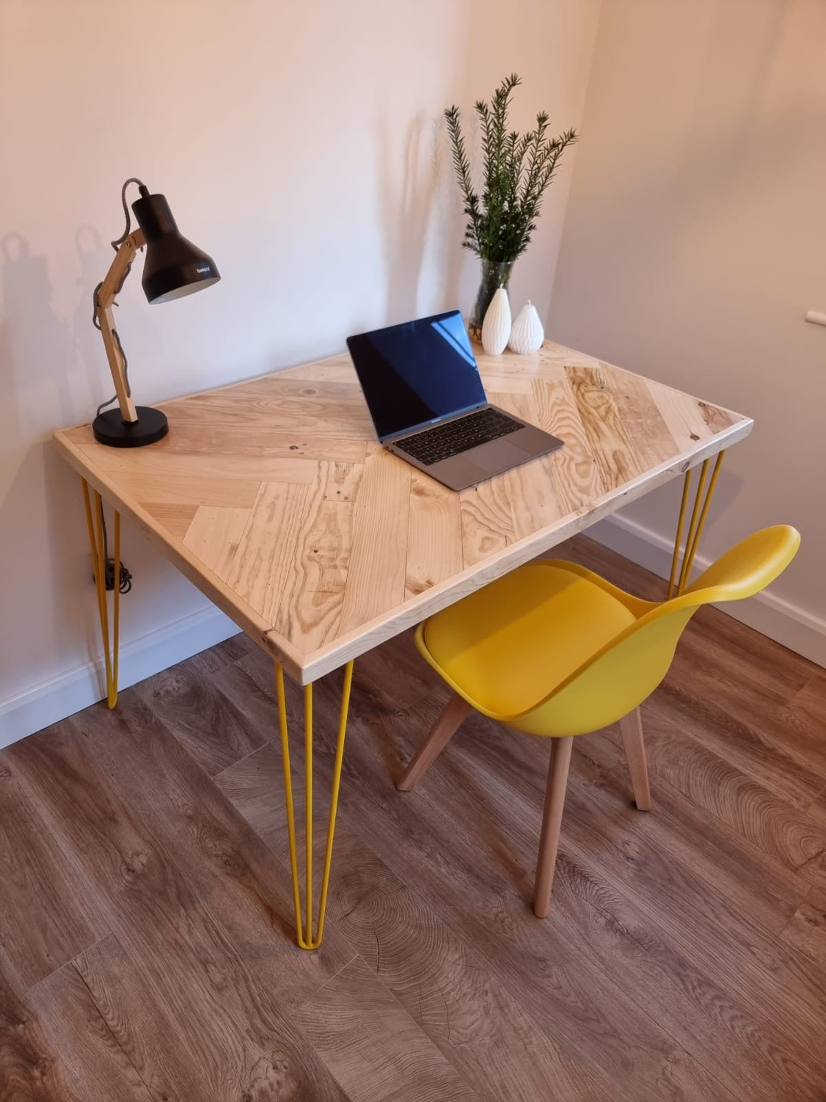 Reclaimed wood desk with herringbone top and black industrial metal legs, featuring a smooth wax finish and natural wood variations