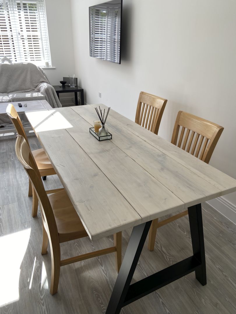 Dining room with a wooden table and chairs in a well-lit room.
