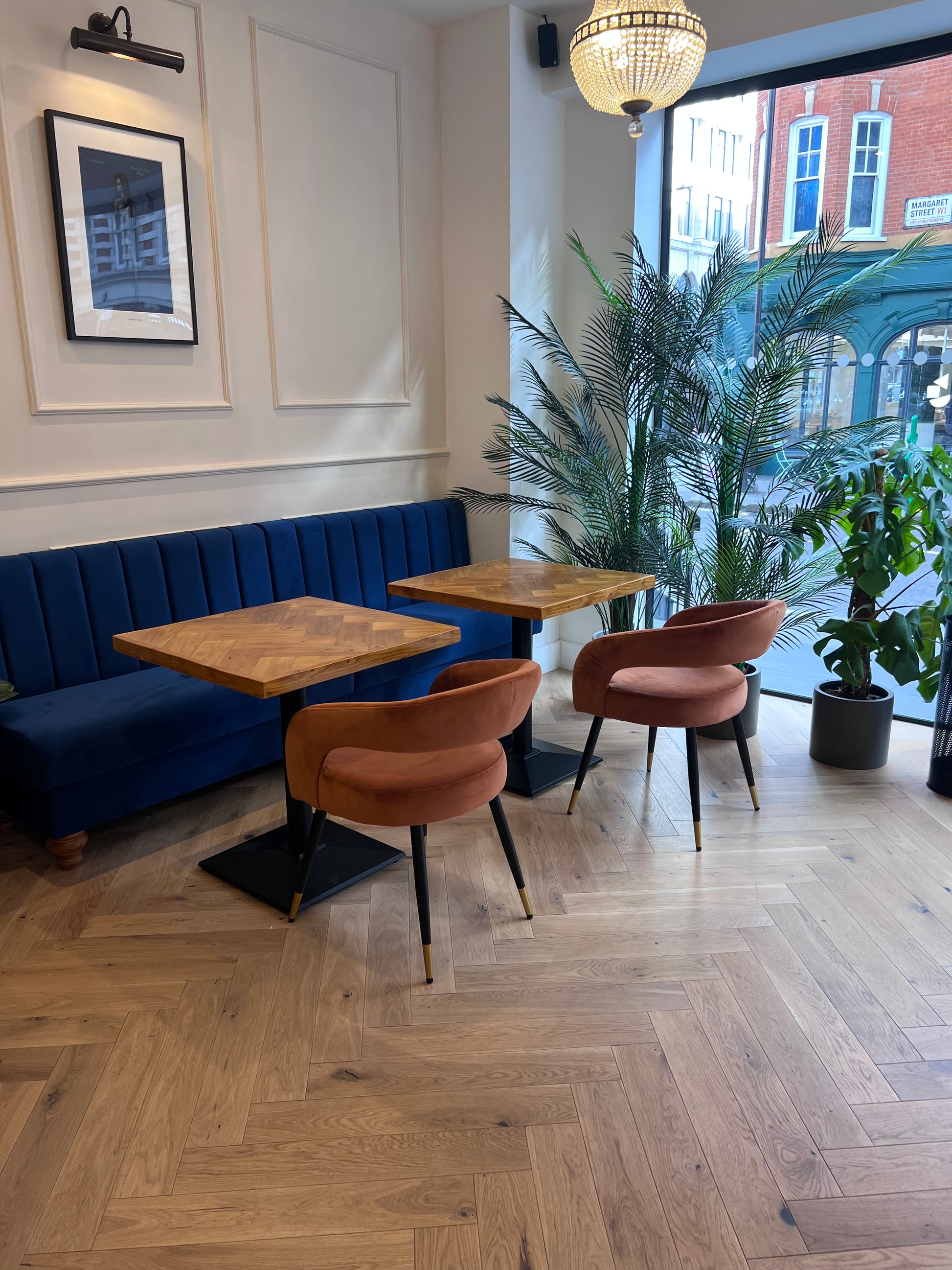 Handmade square bistro table with double herringbone reclaimed wood top and black cast iron pedestal base, finished with natural wax