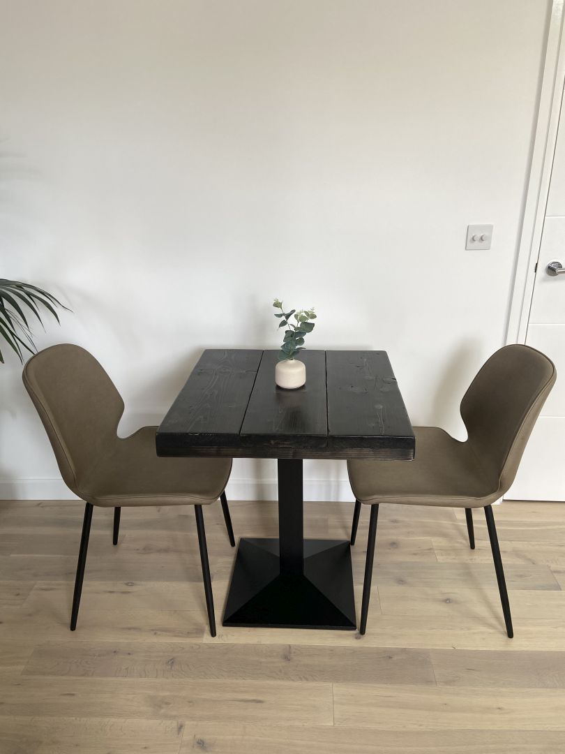 Square bistro table with reclaimed scaffold board top and black cast iron pedestal base, handcrafted in the UK with a smooth wax finish