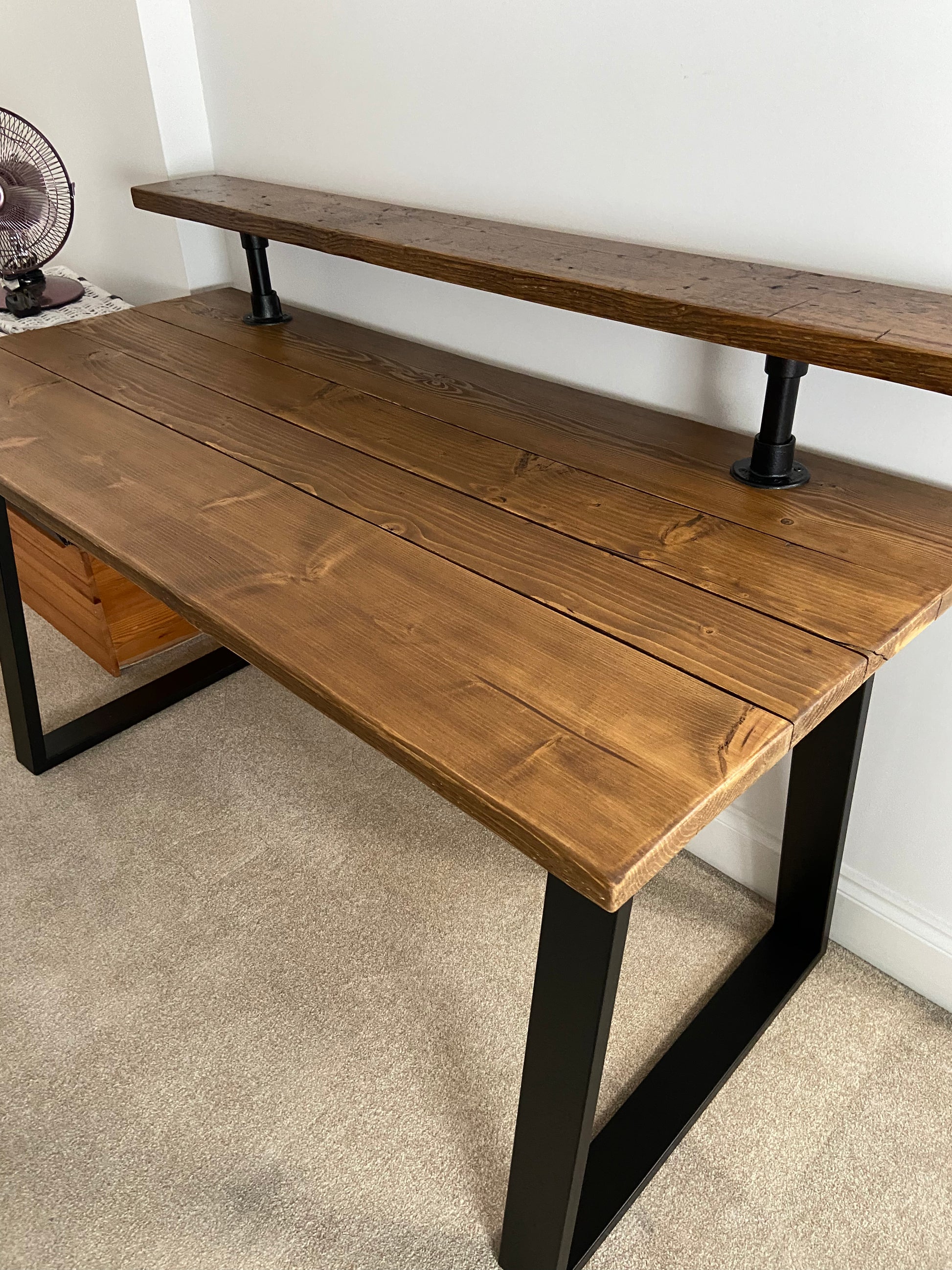 Handmade industrial desk with monitor shelf crafted from reclaimed wood and steel legs – rustic and modern workspace design.