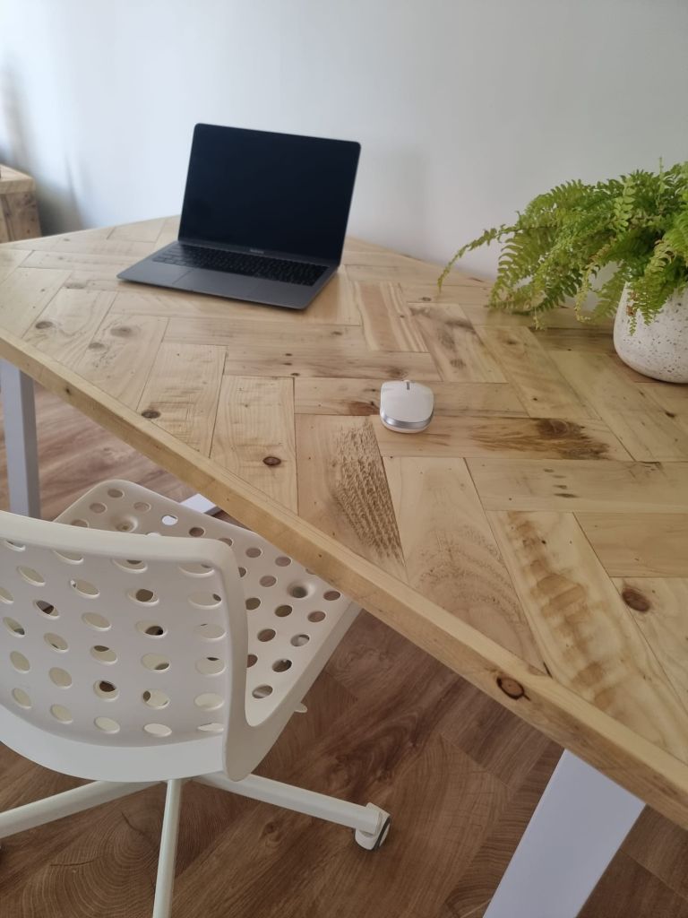 Handcrafted desk with double herringbone reclaimed wood top and industrial metal legs – rustic yet modern design for home office or workspace.
