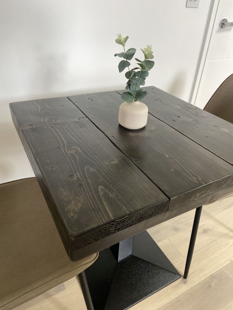 Square bistro table with reclaimed scaffold board top and black cast iron pedestal base, handcrafted in the UK with a smooth wax finish