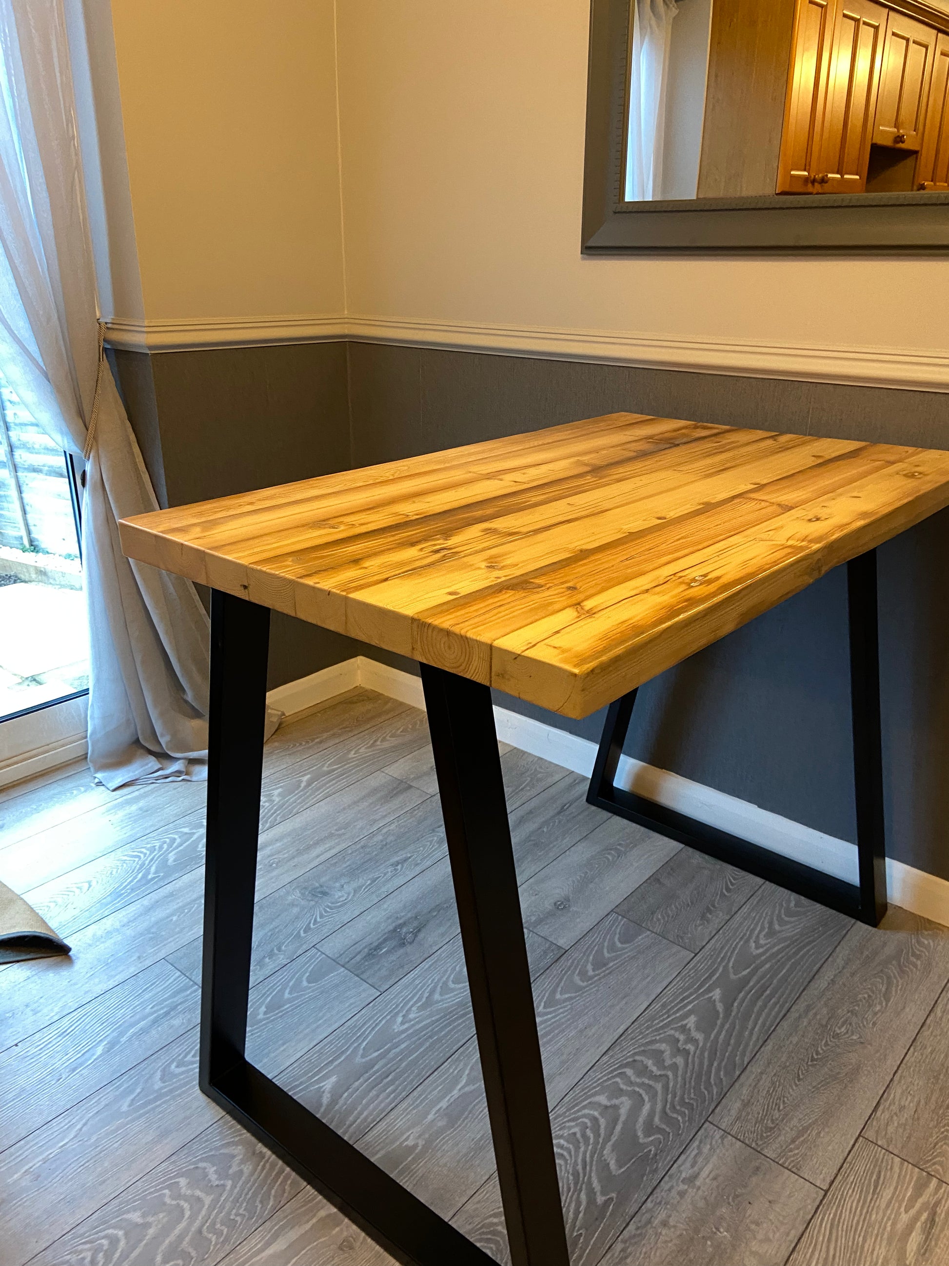 Handcrafted reclaimed wood breakfast bar made from aged joists, featuring natural imperfections, a smooth wax finish, and 90cm high industrial metal legs