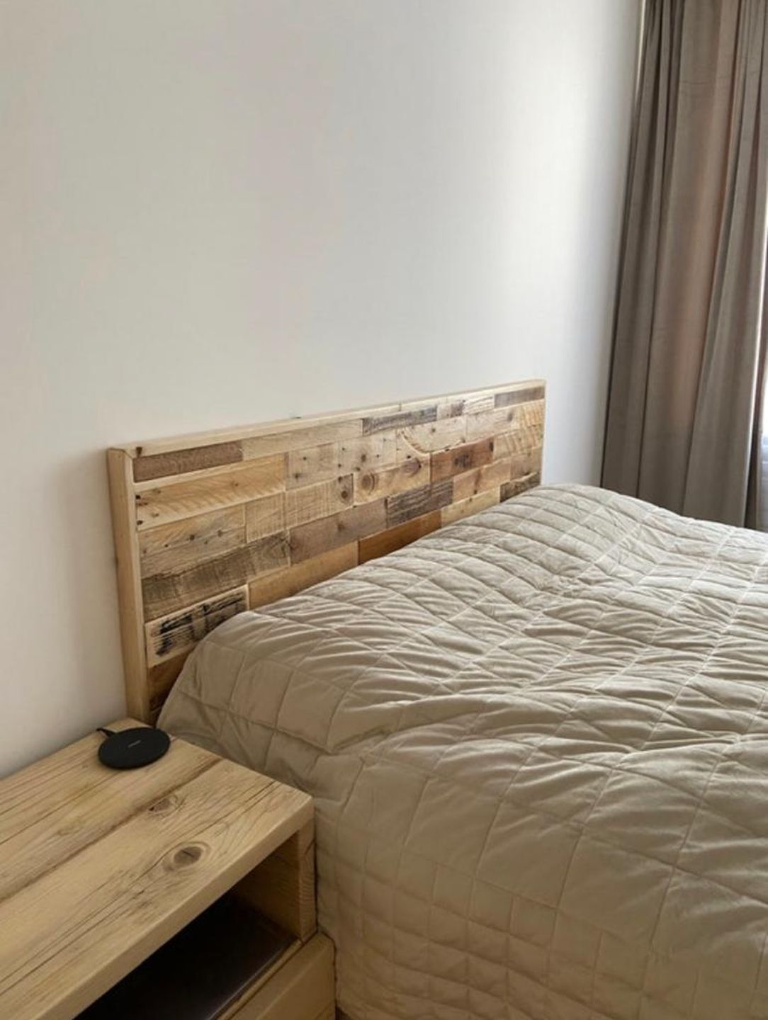Wall-mounted headboard made from reclaimed wood planks with natural rustic finish – handmade and eco-friendly design