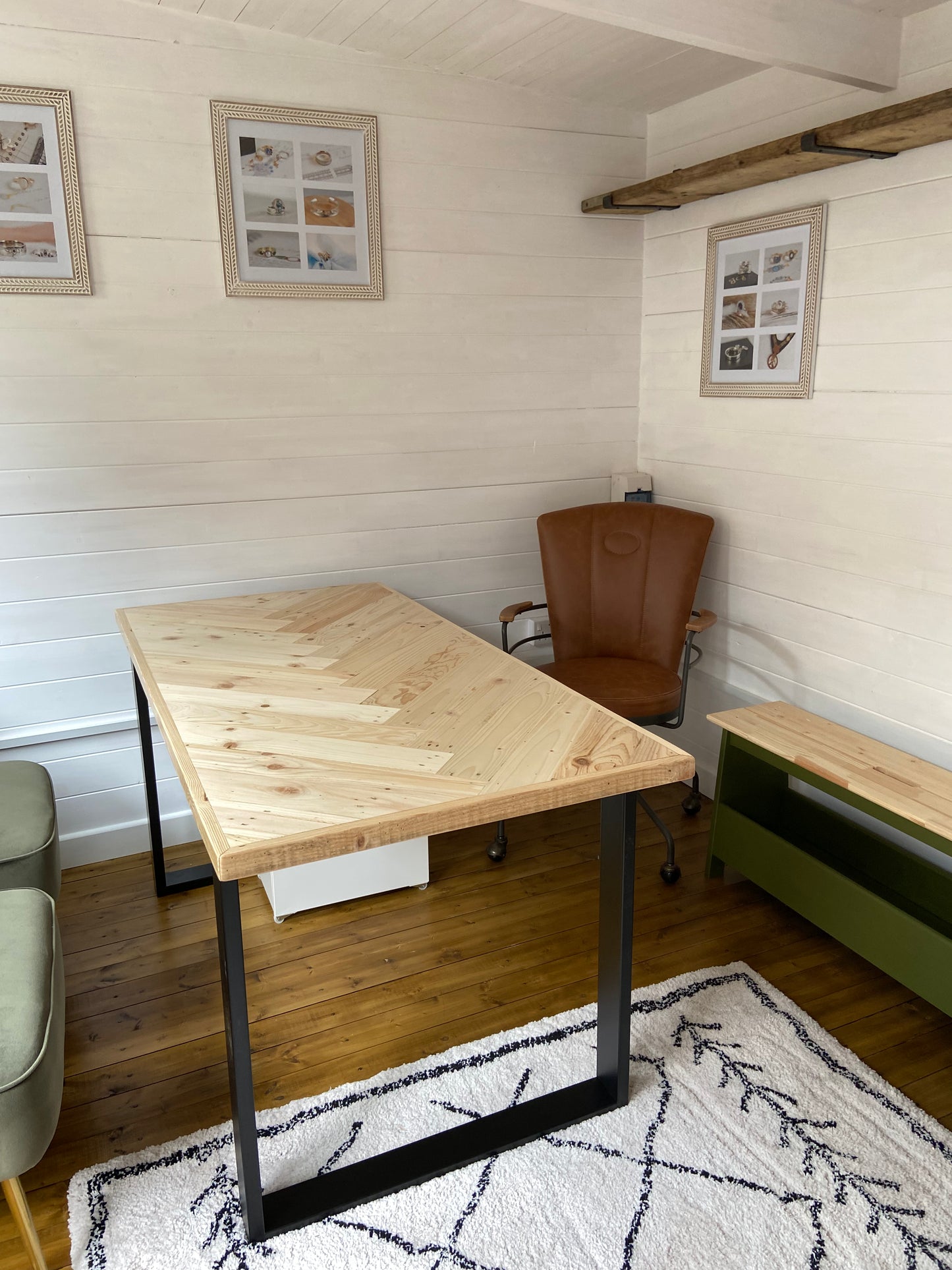 Reclaimed wood desk with herringbone top and black industrial metal legs, featuring a smooth wax finish and natural wood variations