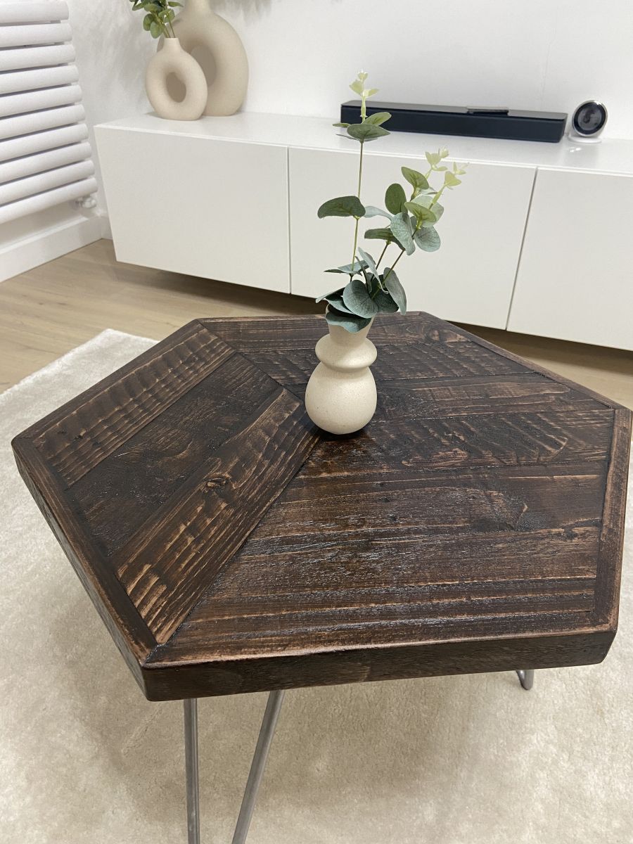 Hexagonal reclaimed wood coffee table with raw steel hairpin legs, rustic handcrafted design with eco-friendly wax finish