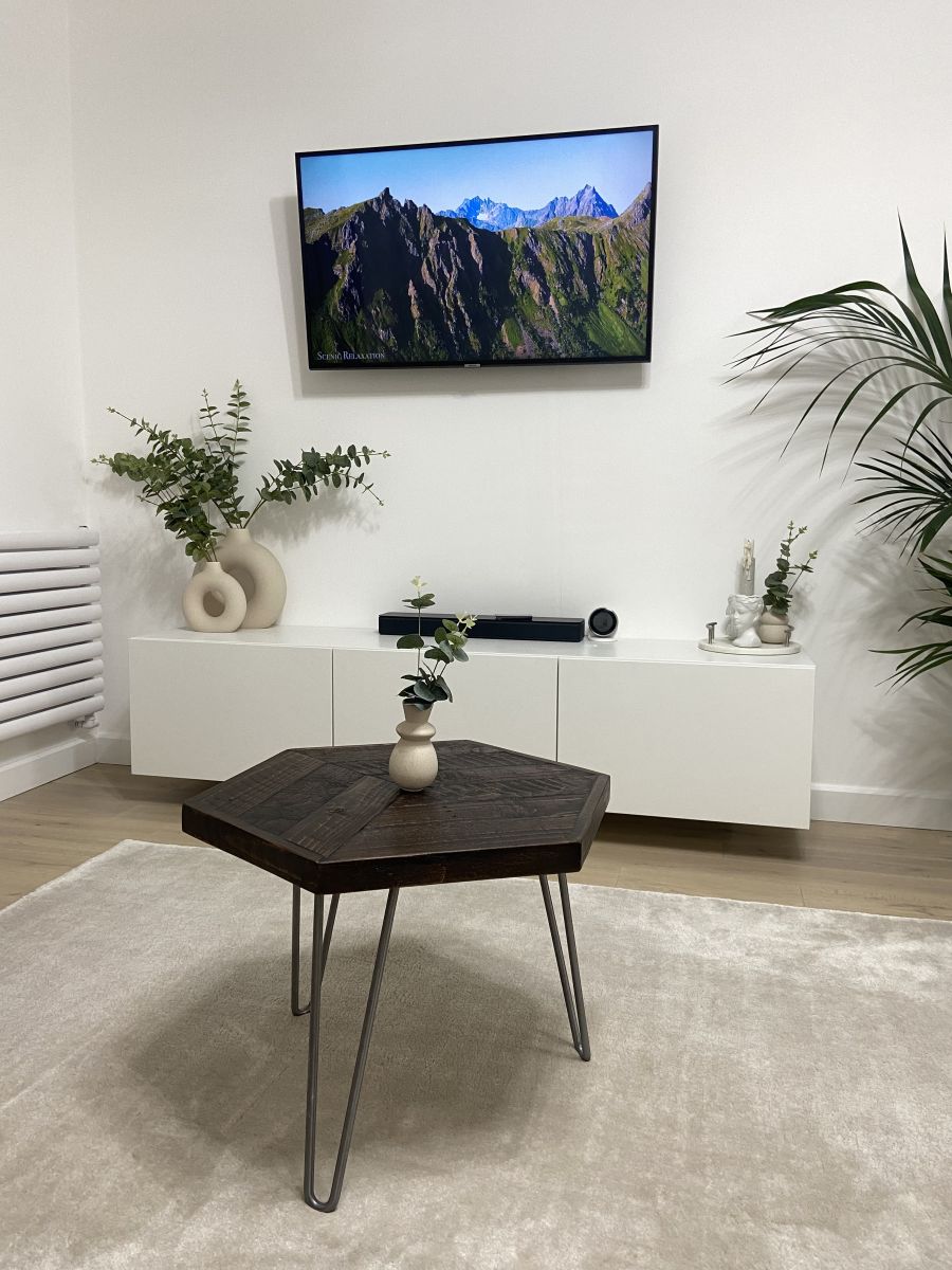 Hexagonal reclaimed wood coffee table with raw steel hairpin legs, rustic handcrafted design with eco-friendly wax finish