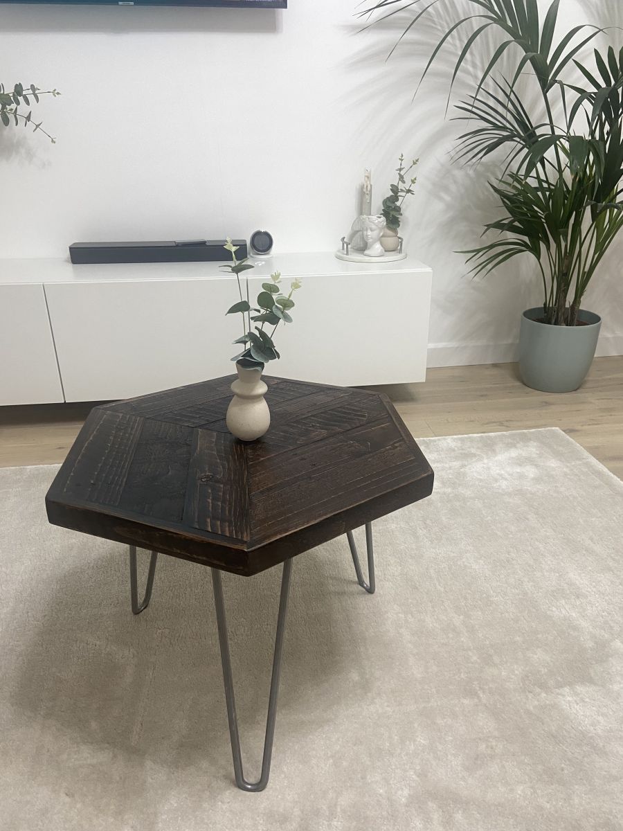 Hexagonal reclaimed wood coffee table with raw steel hairpin legs, rustic handcrafted design with eco-friendly wax finish