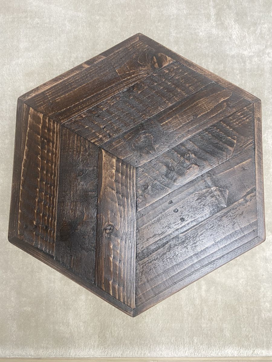 Hexagonal reclaimed wood coffee table with raw steel hairpin legs, rustic handcrafted design with eco-friendly wax finish