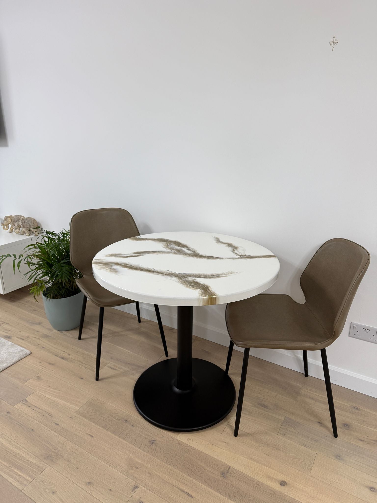 Handmade round epoxy resin dining table with 3.6 cm thick top and cast iron pedestal base – made to order in the UK.