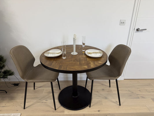 Handmade round reclaimed wood dining table with double herringbone pattern, smooth sanded top, and natural wax finish – rustic and elegant UK craftsmanship