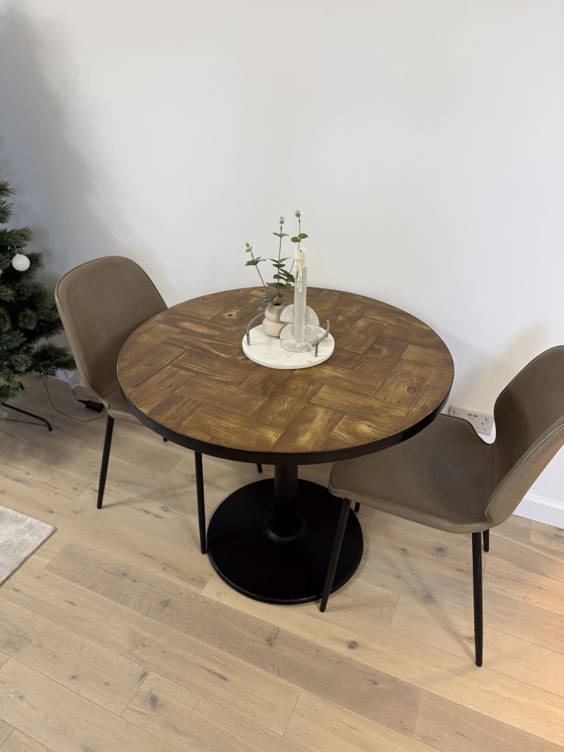 Handmade round reclaimed wood dining table with double herringbone pattern, smooth sanded top, and natural wax finish – rustic and elegant UK craftsmanship