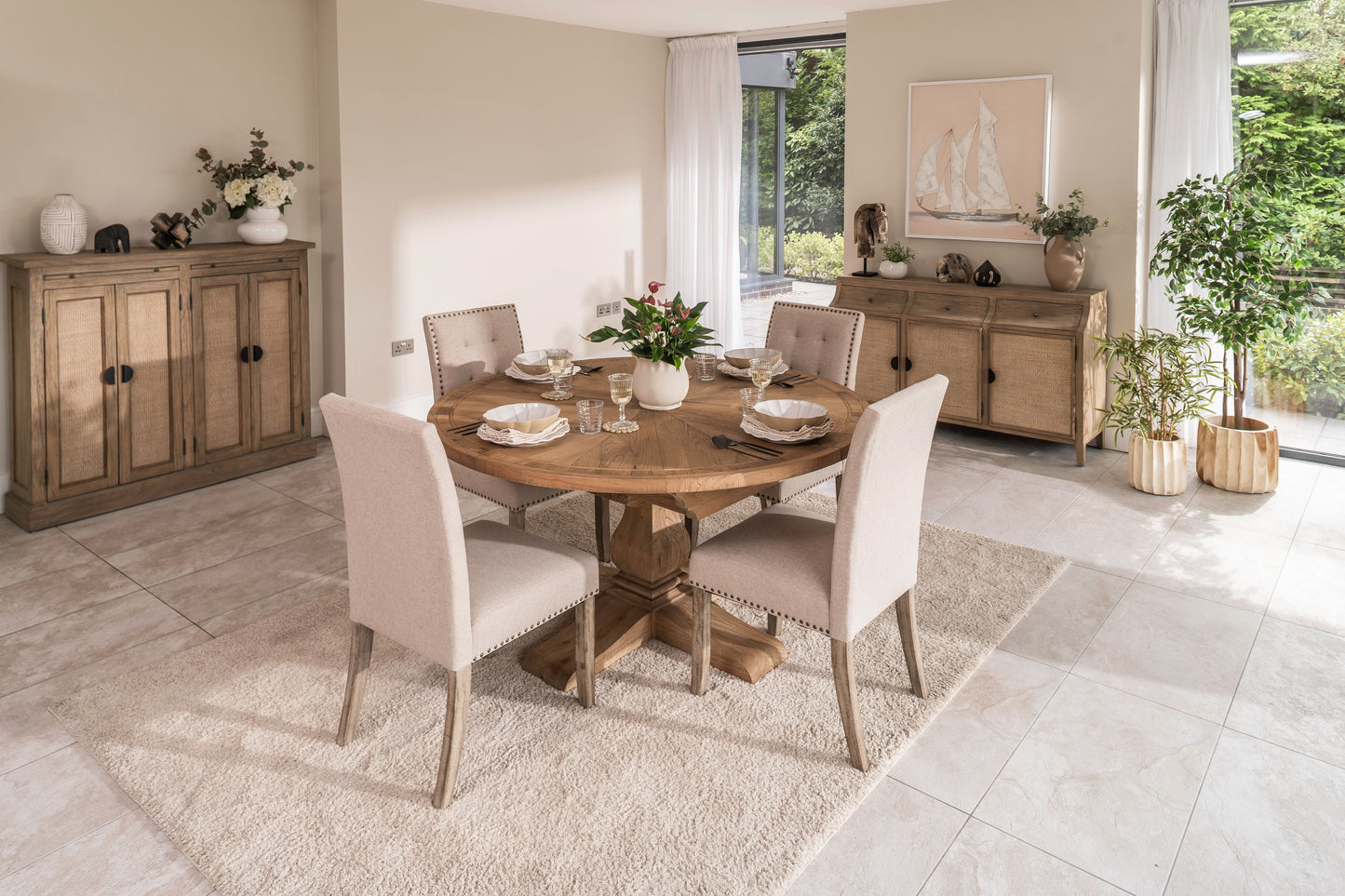 Round solid oak extending dining table in classic farmhouse style, styled in a bright dining area. Part of the Elmstead Series by TheRoughWood.