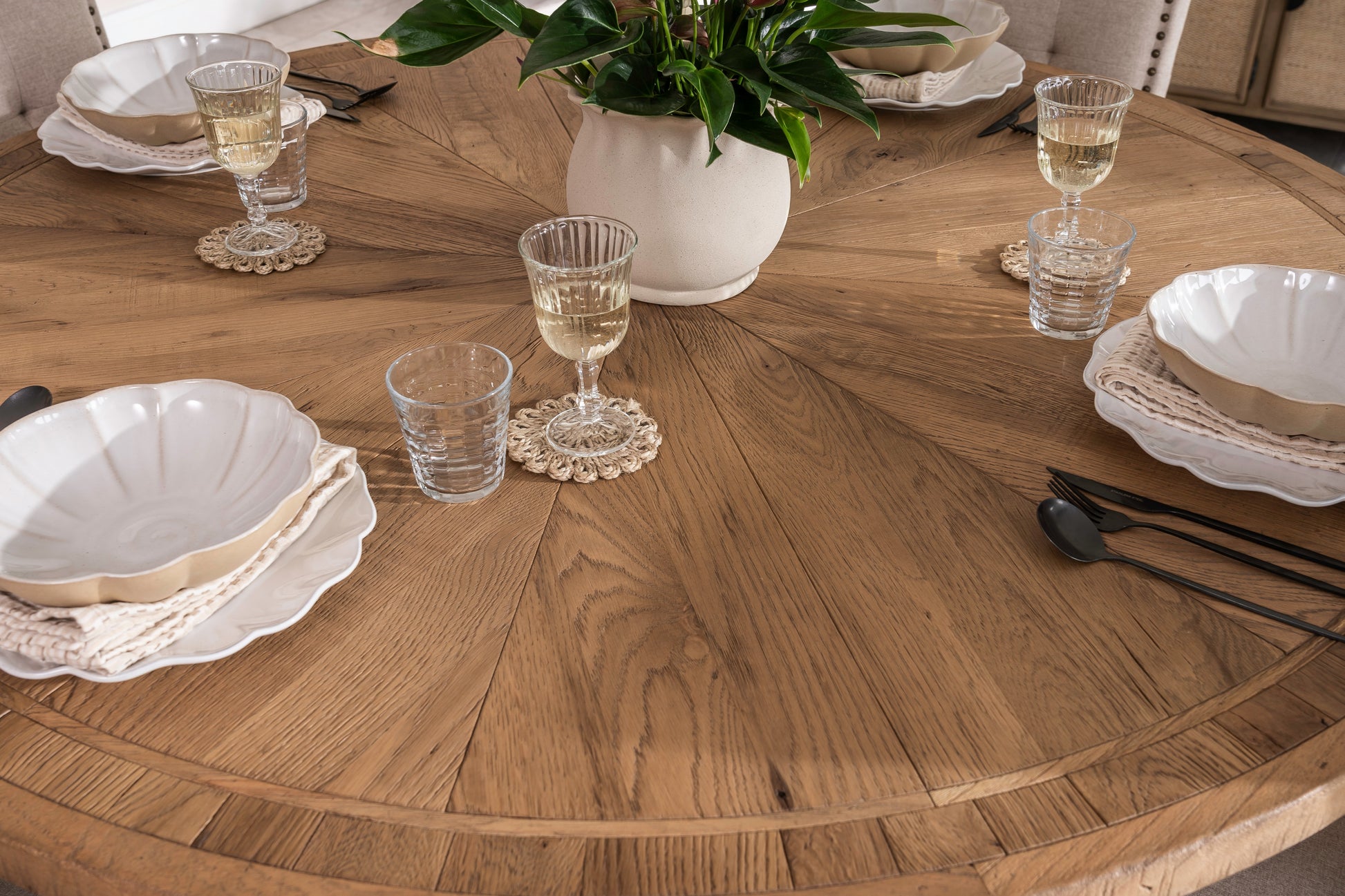 Round solid oak extending dining table in classic farmhouse style, styled in a bright dining area. Part of the Elmstead Series by TheRoughWood.