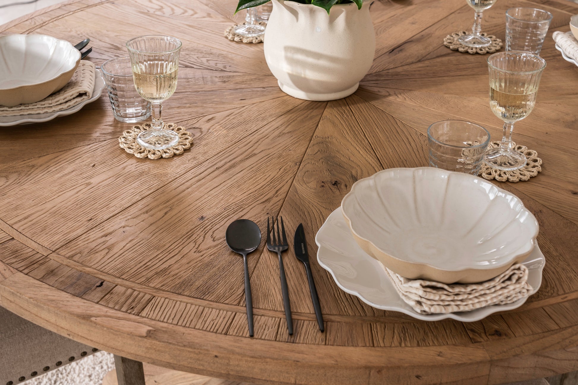 Round solid oak extending dining table in classic farmhouse style, styled in a bright dining area. Part of the Elmstead Series by TheRoughWood.