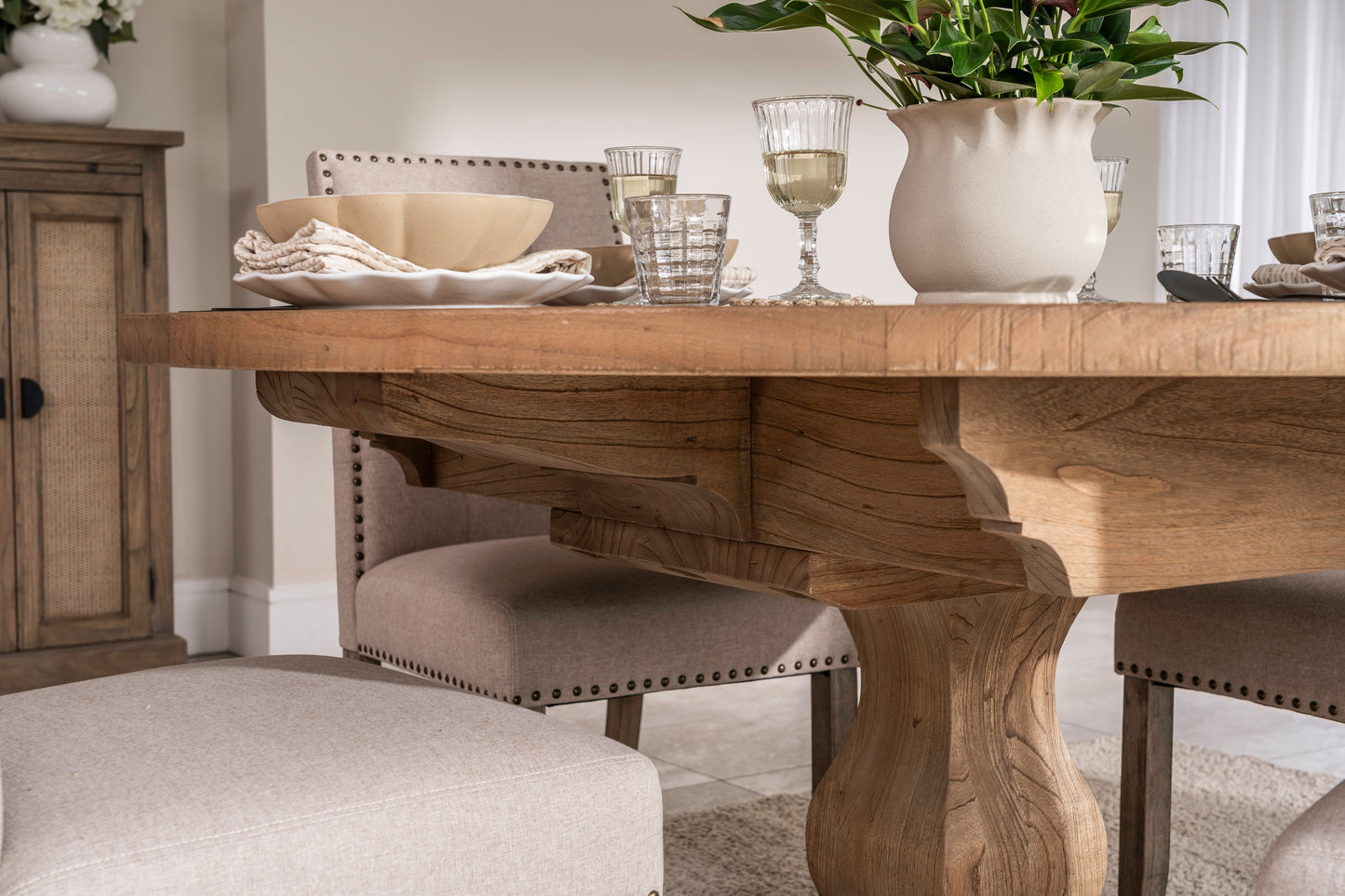 Round solid oak extending dining table in classic farmhouse style, styled in a bright dining area. Part of the Elmstead Series by TheRoughWood.