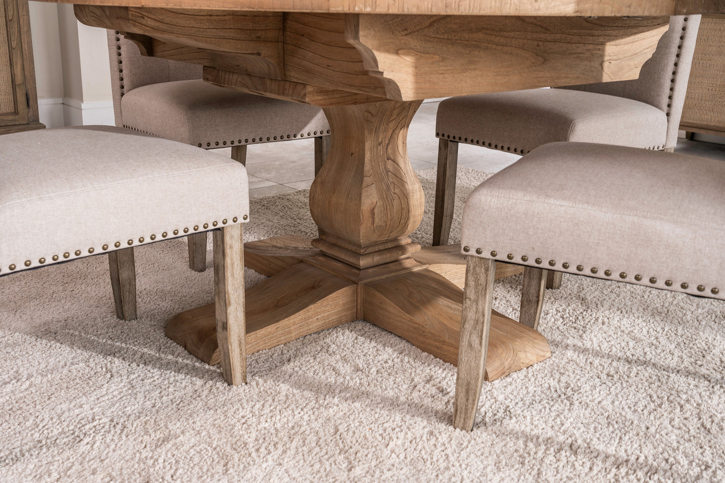 Round solid oak extending dining table in classic farmhouse style, styled in a bright dining area. Part of the Elmstead Series by TheRoughWood.