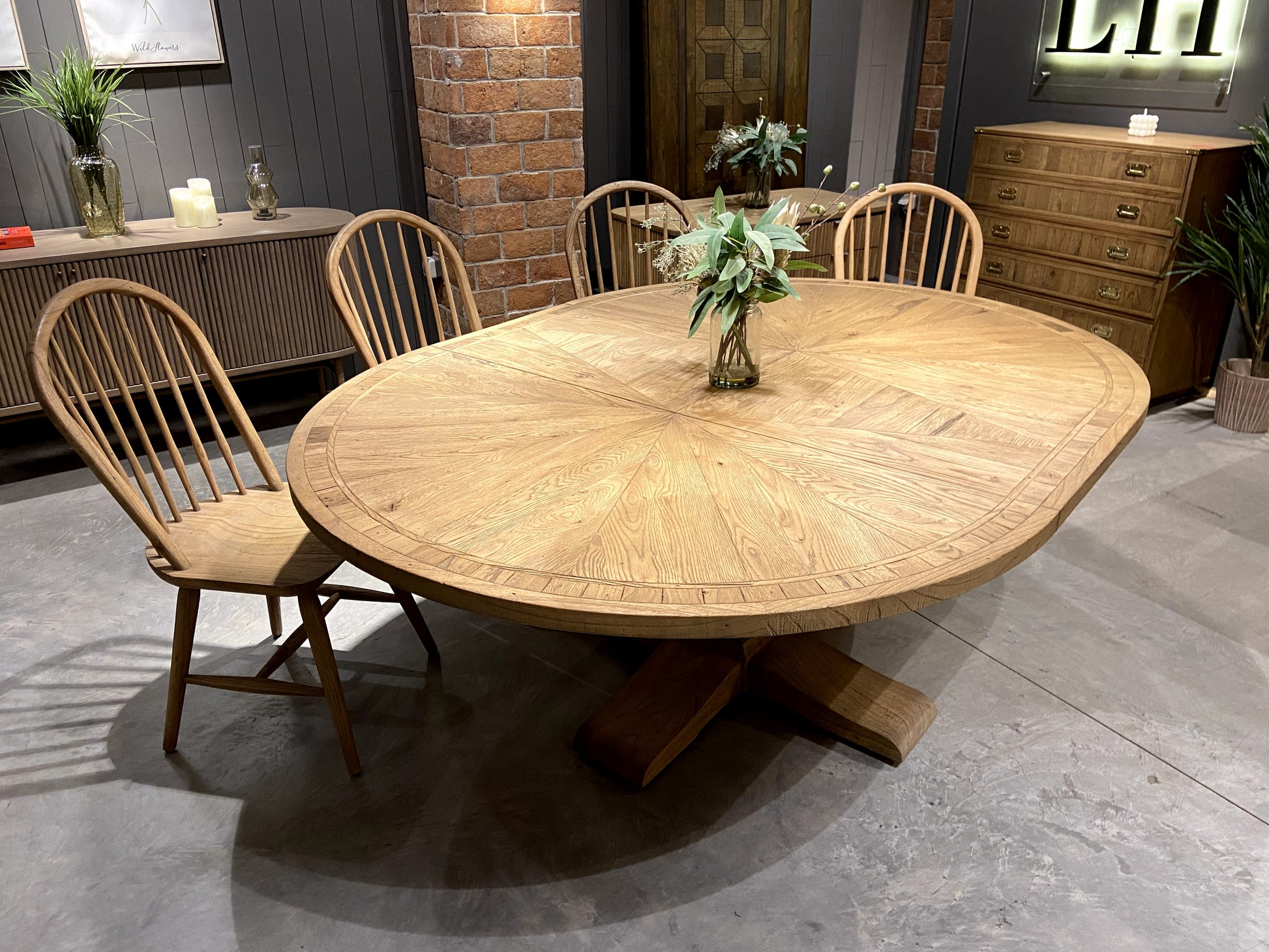 Round solid oak extending dining table in classic farmhouse style, styled in a bright dining area. Part of the Elmstead Series by TheRoughWood.