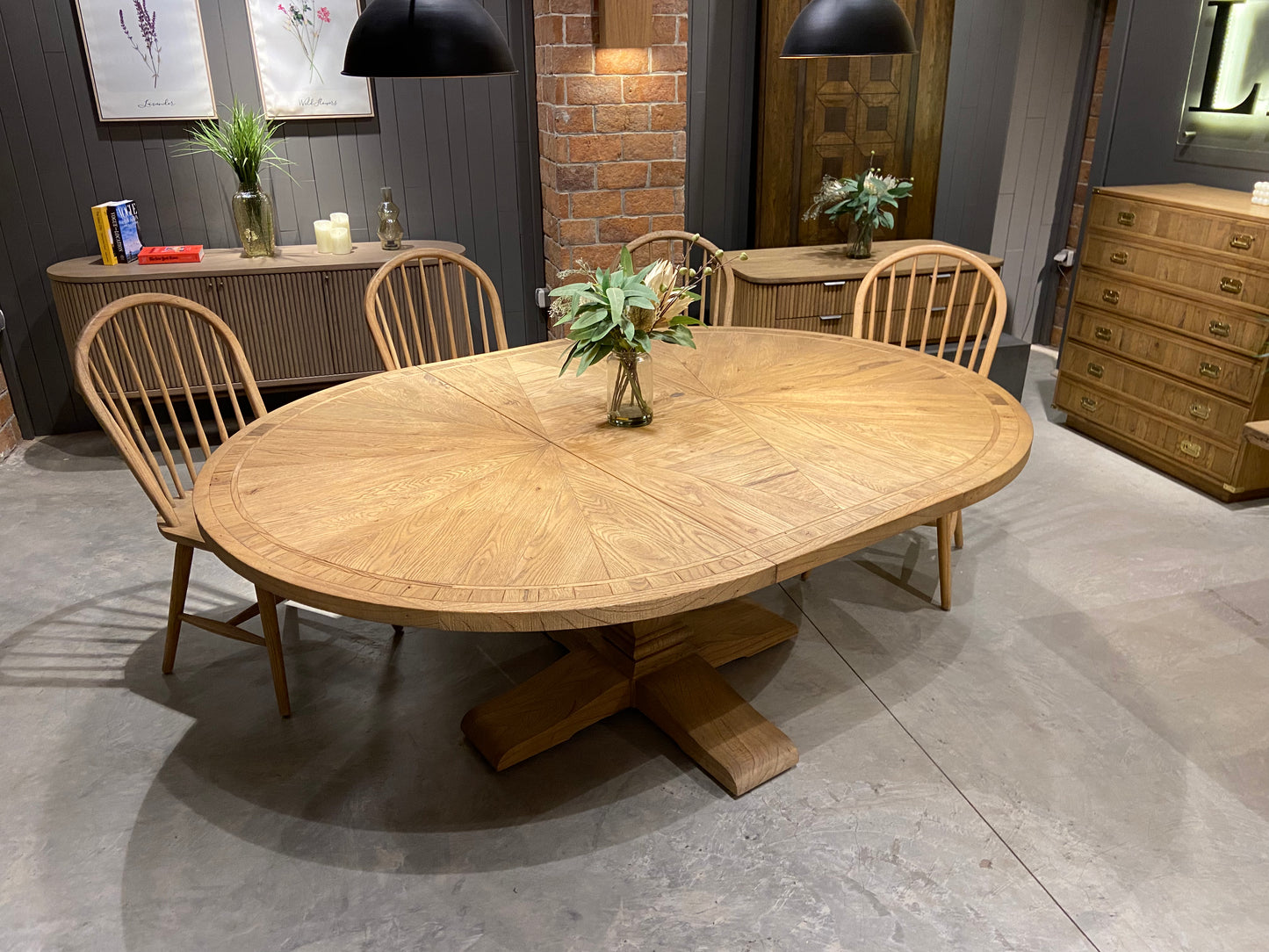 Round solid oak extending dining table in classic farmhouse style, styled in a bright dining area. Part of the Elmstead Series by TheRoughWood.