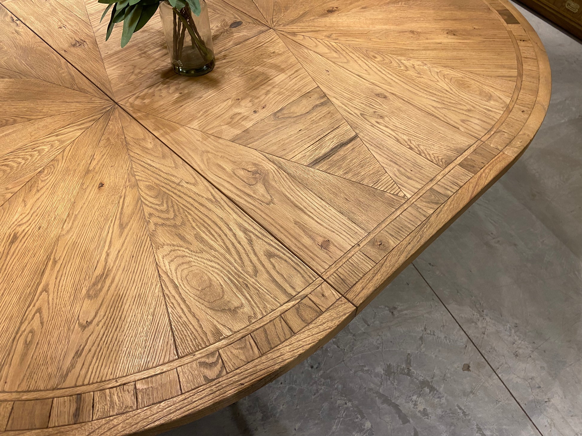 Round solid oak extending dining table in classic farmhouse style, styled in a bright dining area. Part of the Elmstead Series by TheRoughWood.