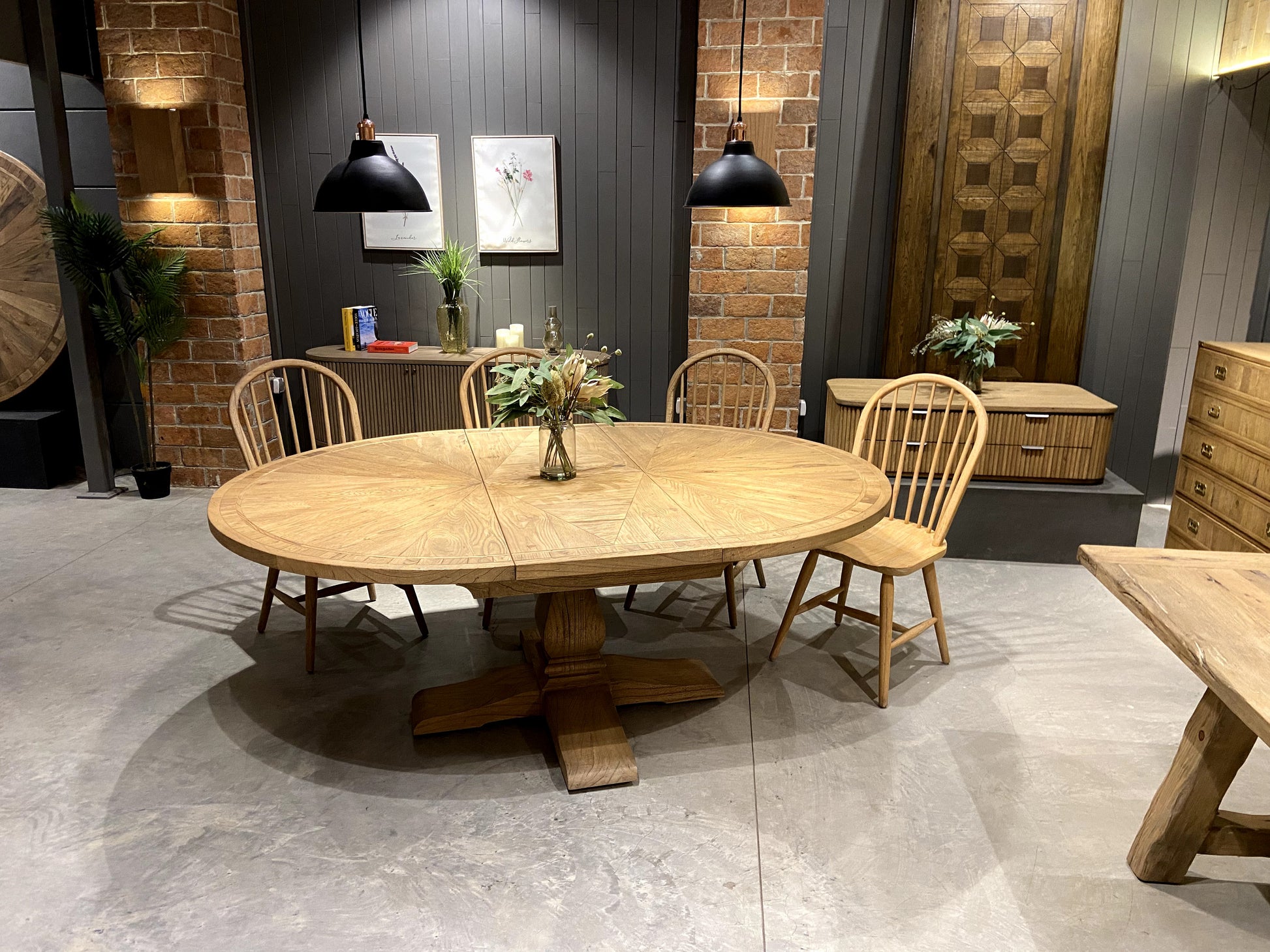 Round solid oak extending dining table in classic farmhouse style, styled in a bright dining area. Part of the Elmstead Series by TheRoughWood.