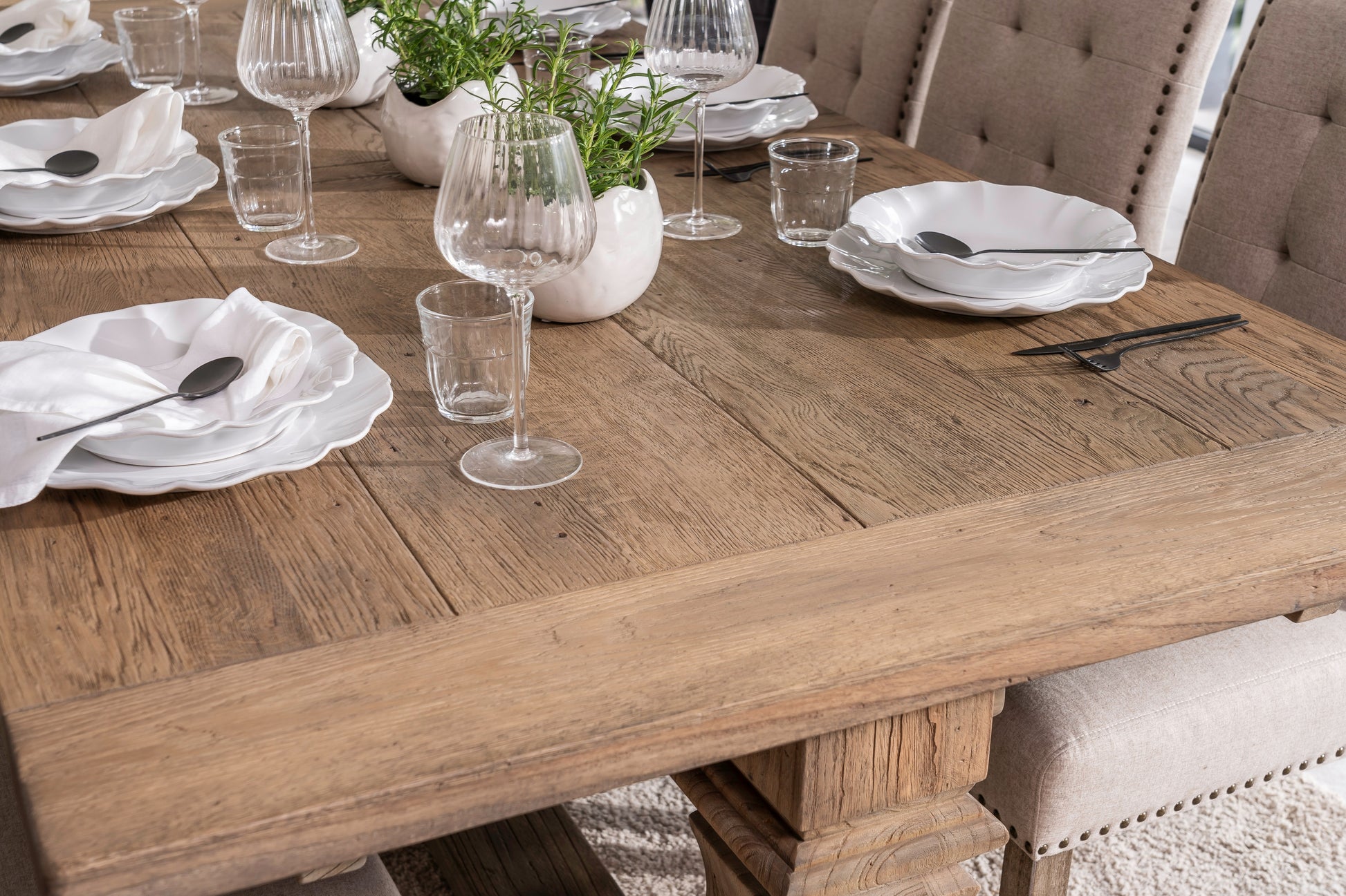 Solid oak extending dining table with pedestal base, shown styled in a neutral dining room. Part of the Elmstead Series by TheRoughWood.