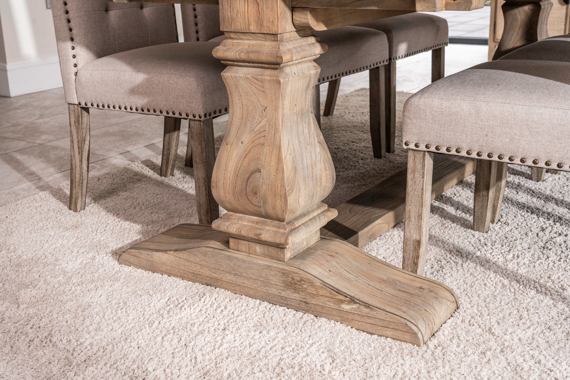 Solid oak extending dining table with pedestal base, shown styled in a neutral dining room. Part of the Elmstead Series by TheRoughWood.
