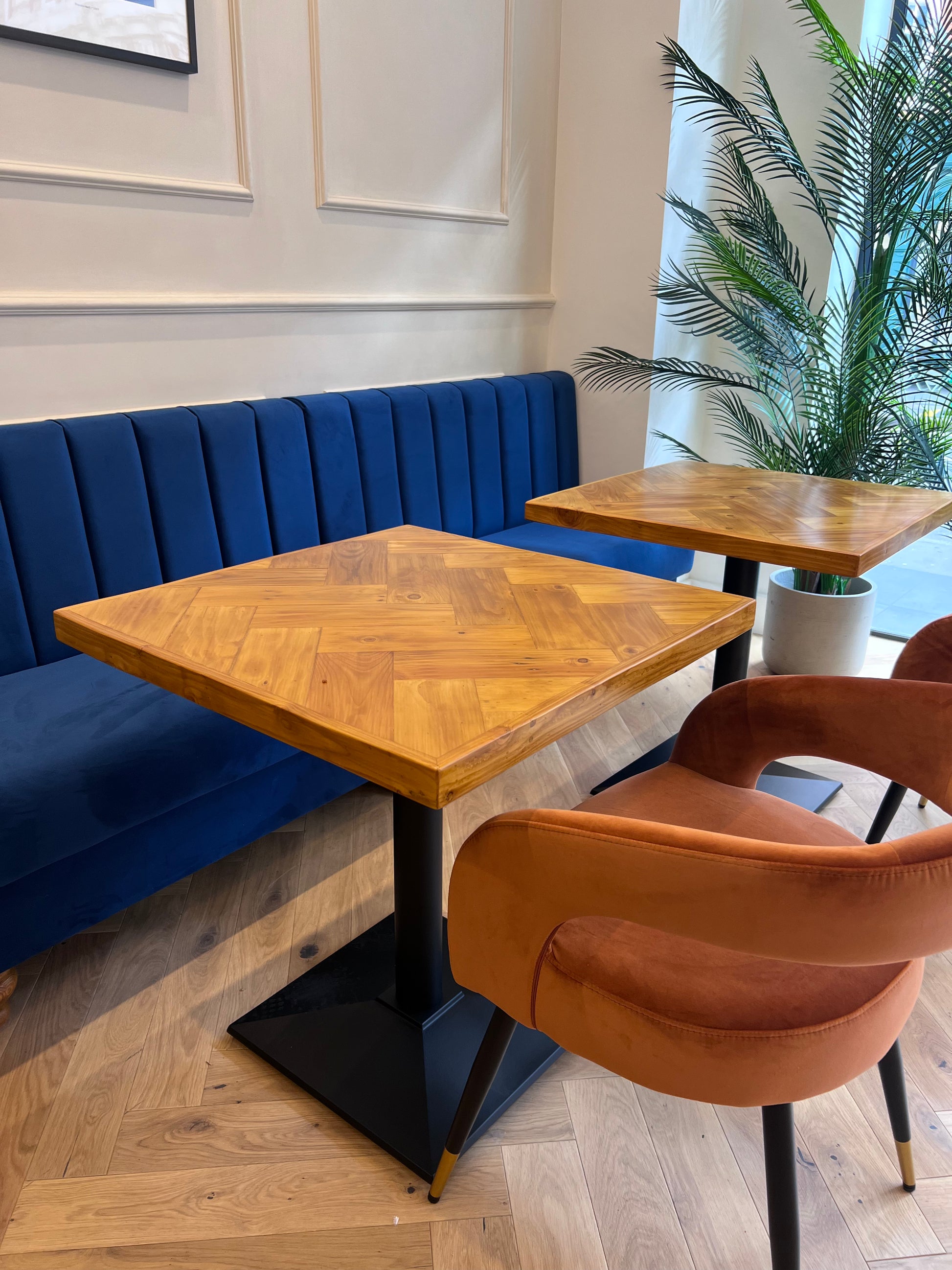 Handmade square bistro table with double herringbone reclaimed wood top and black cast iron pedestal base, finished with natural wax