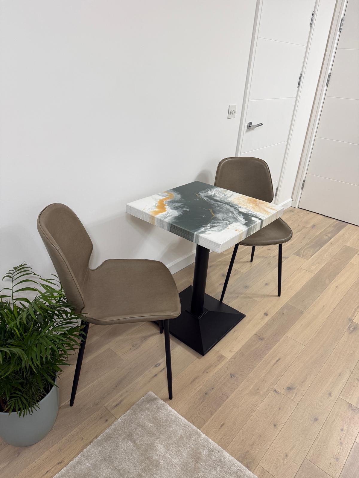Handmade square epoxy resin dining table with artistic top and cast iron pedestal base – made to order in the UK.
