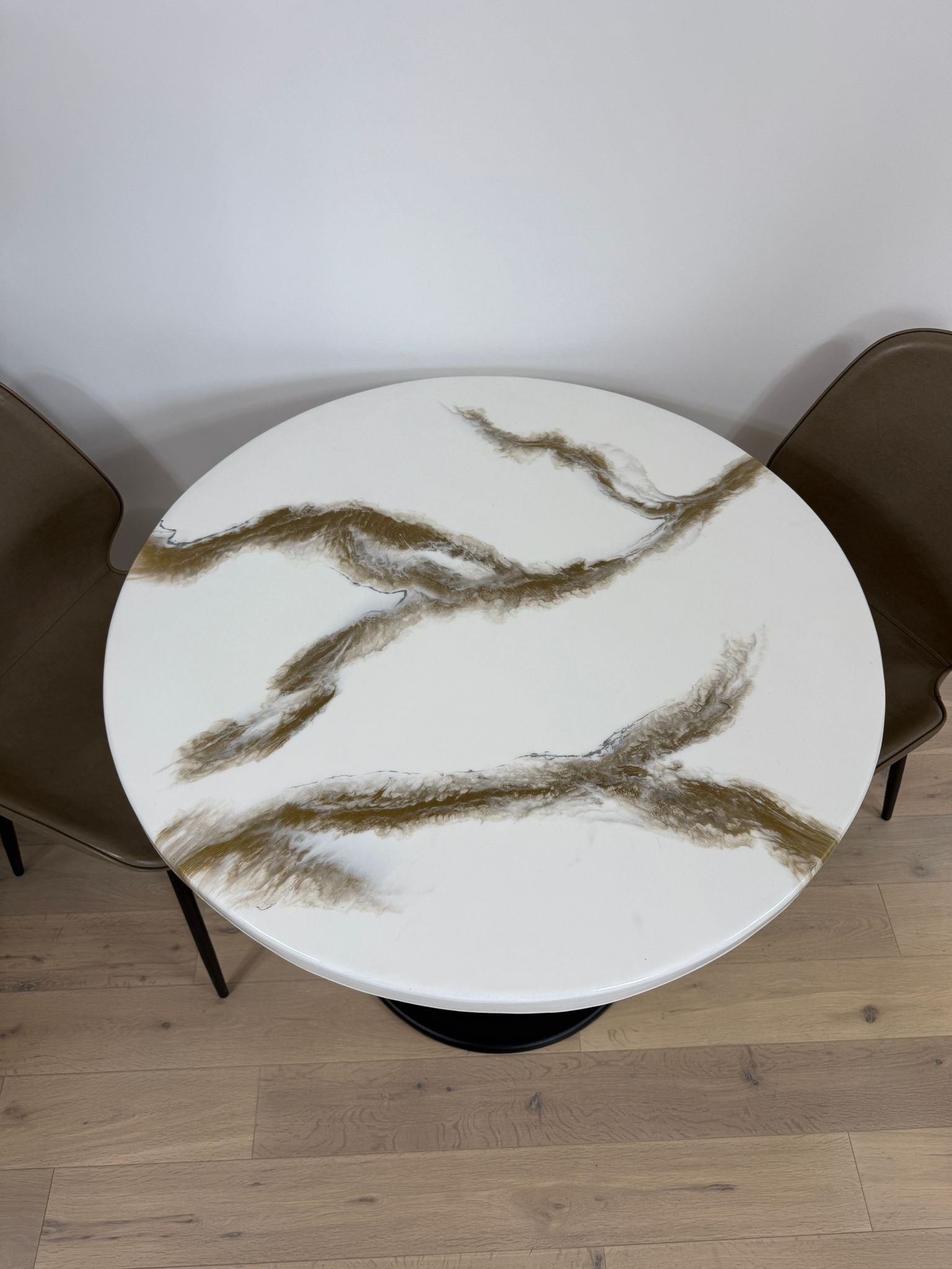 Handmade round epoxy resin dining table with 3.6 cm thick top and cast iron pedestal base – made to order in the UK.