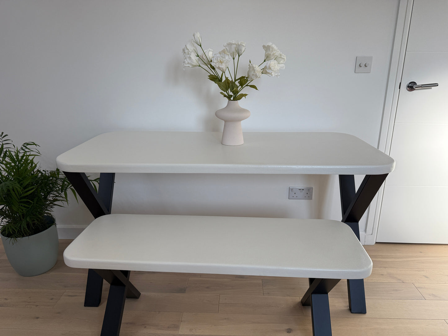 Handmade microcement dining table with white concrete-style top and matching benches, black metal legs – made to order in the UK.