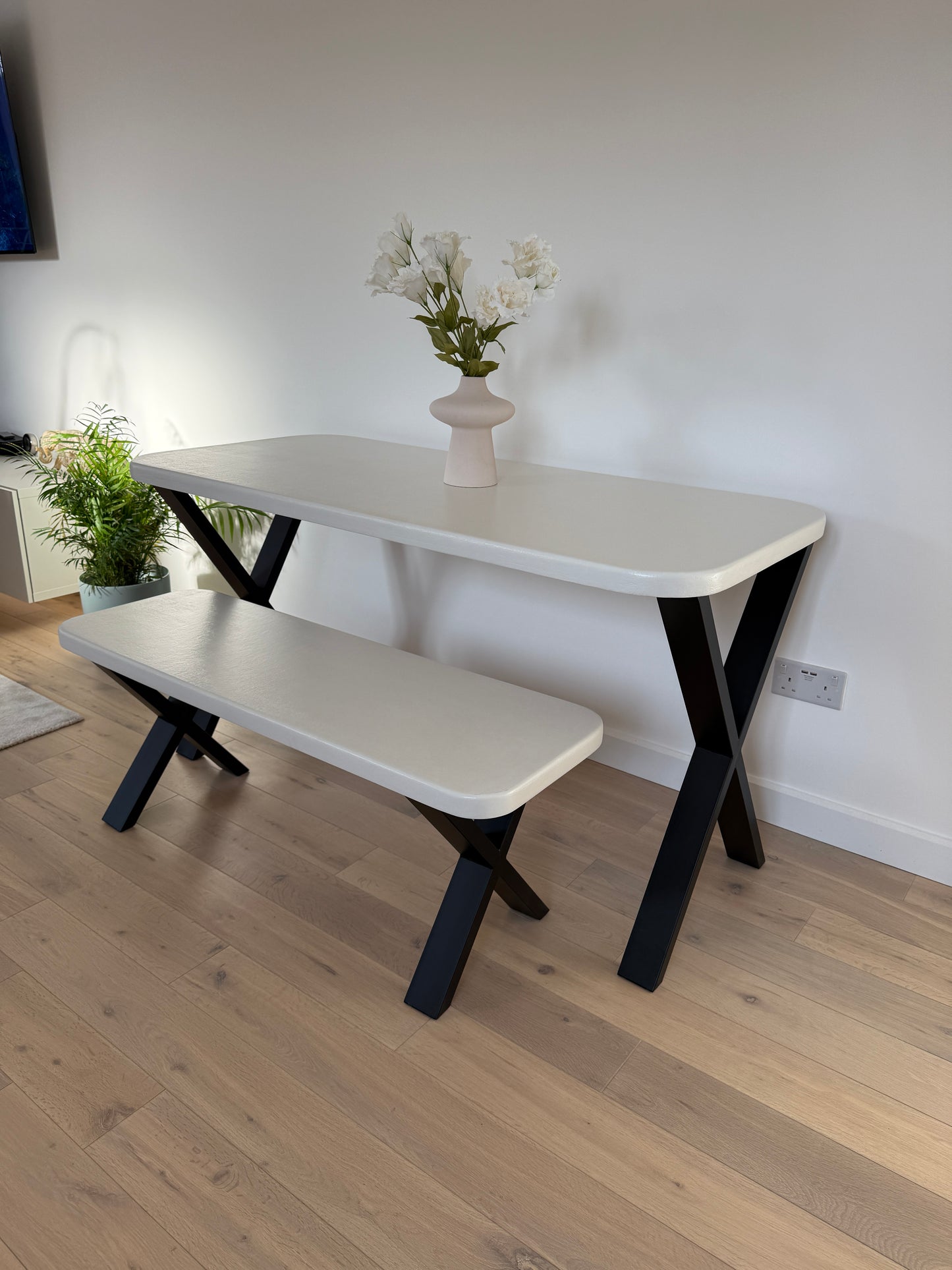 Handmade microcement dining table with white concrete-style top and matching benches, black metal legs – made to order in the UK.
