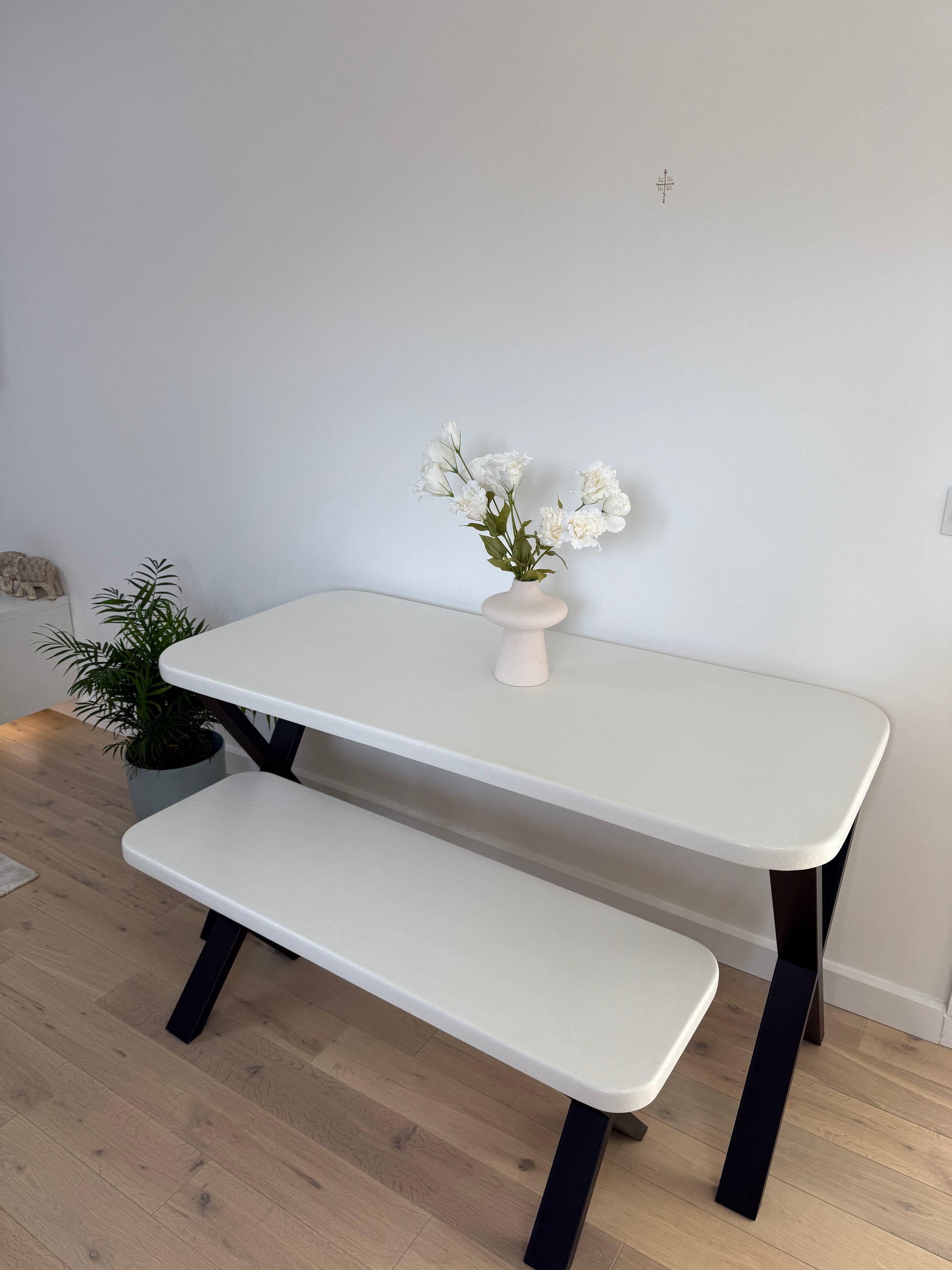 Handmade microcement dining table with white concrete-style top and matching benches, black metal legs – made to order in the UK.