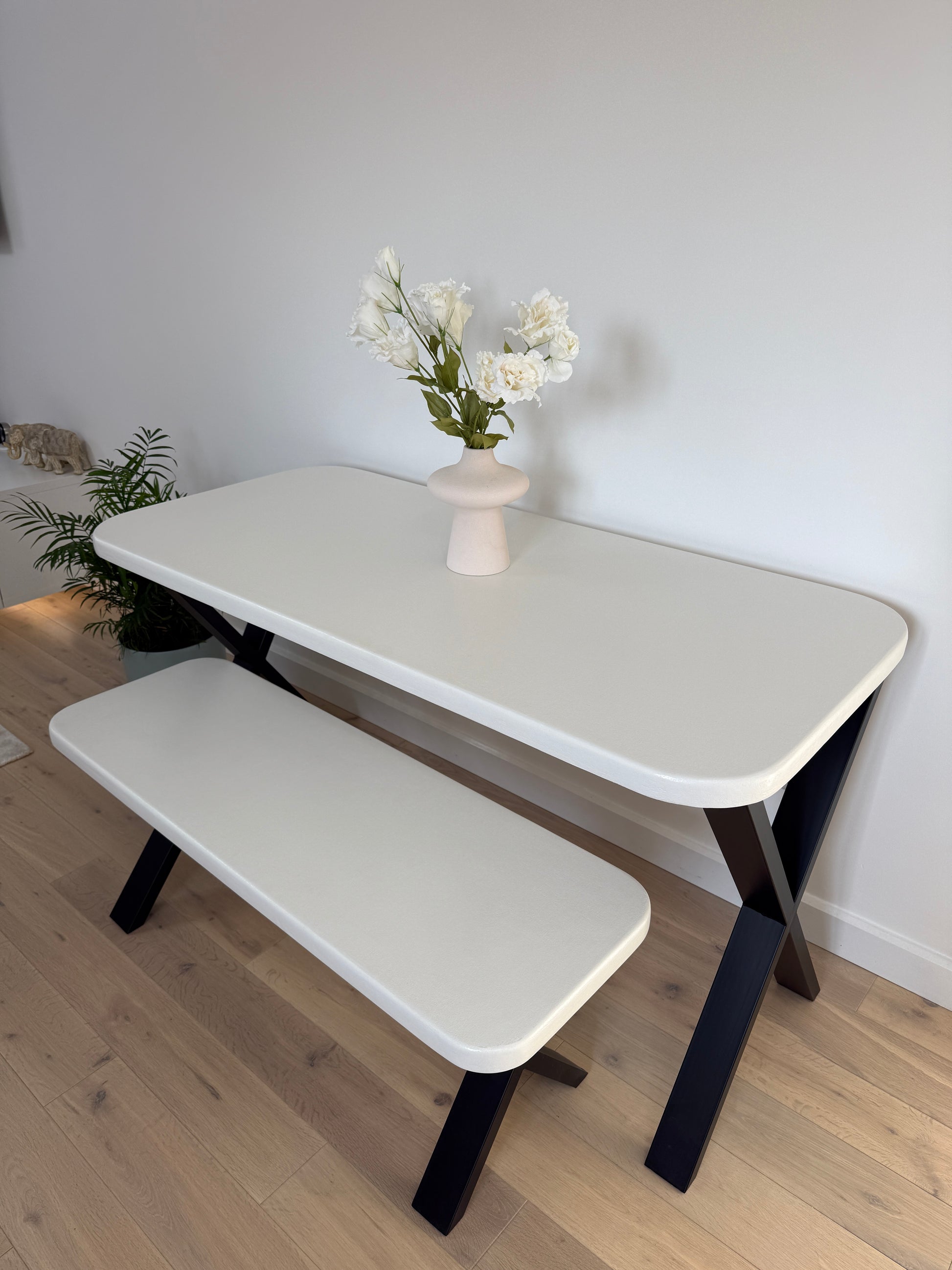 Handmade microcement dining table with white concrete-style top and matching benches, black metal legs – made to order in the UK.