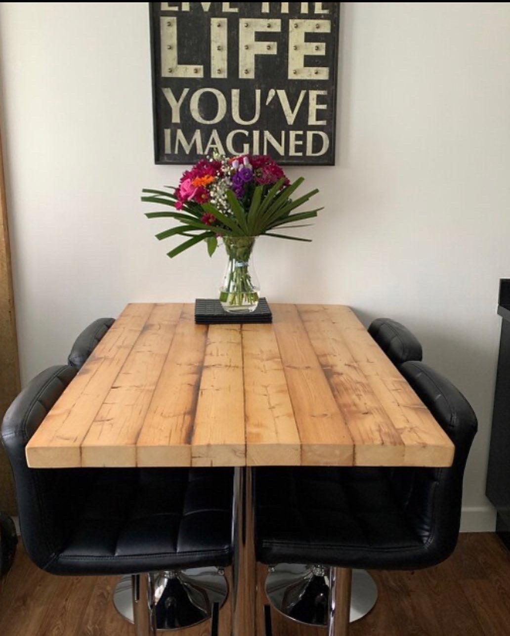 Handcrafted reclaimed wood breakfast bar made from aged joists, featuring natural imperfections, a smooth wax finish, and 90cm high industrial metal legs