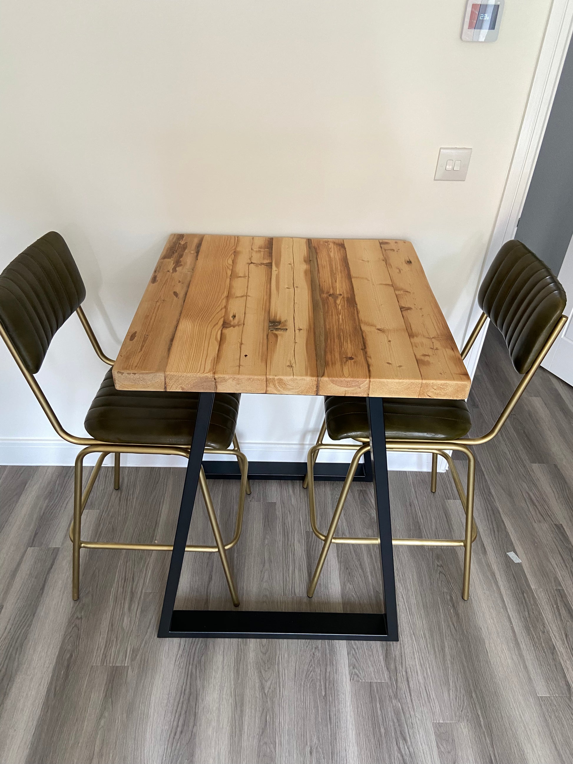 Handcrafted reclaimed wood breakfast bar made from aged joists, featuring natural imperfections, a smooth wax finish, and 90cm high industrial metal legs