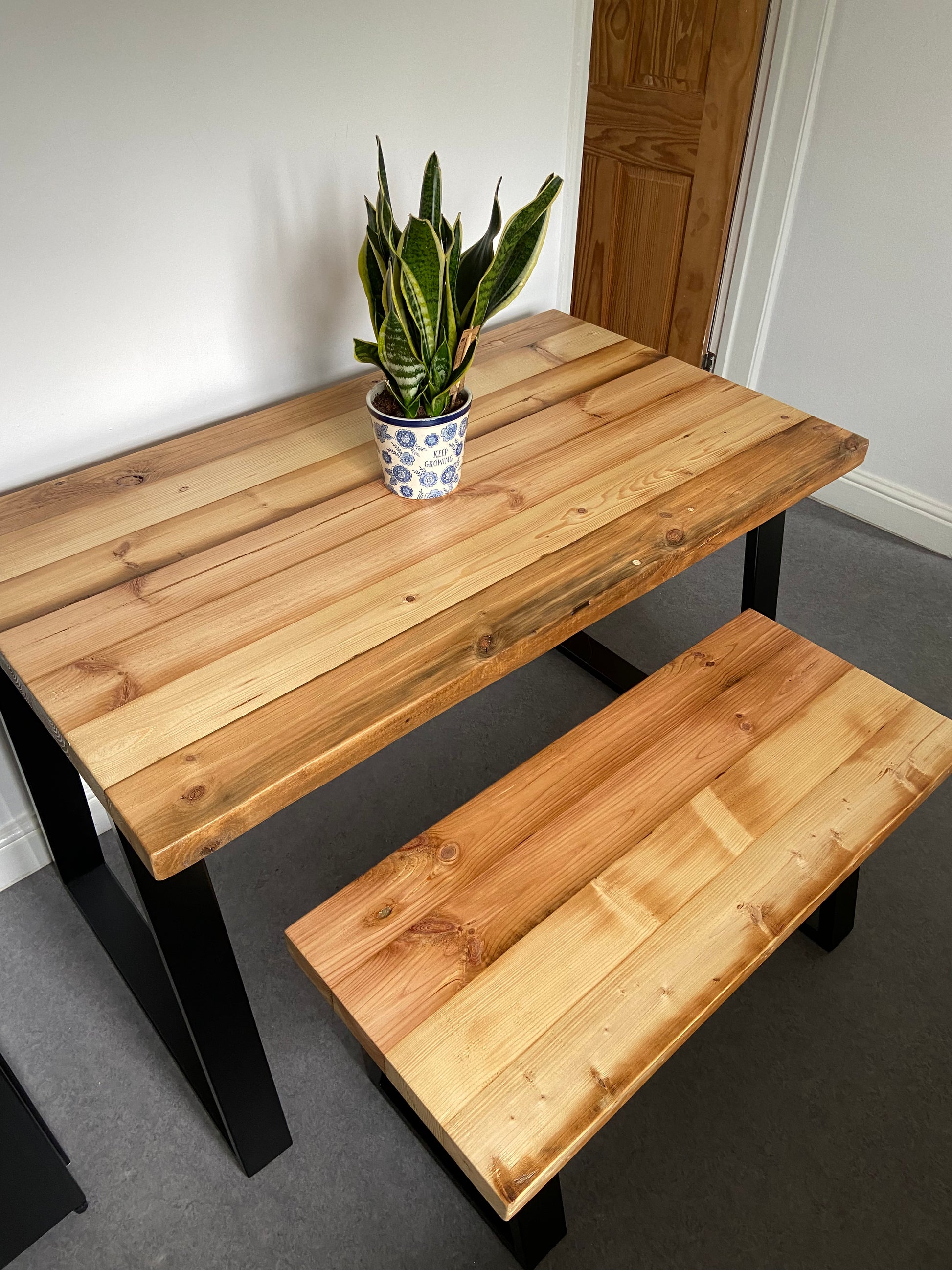 Reclaimed wood dining table with matching benches tucked underneath – rustic industrial style furniture set
