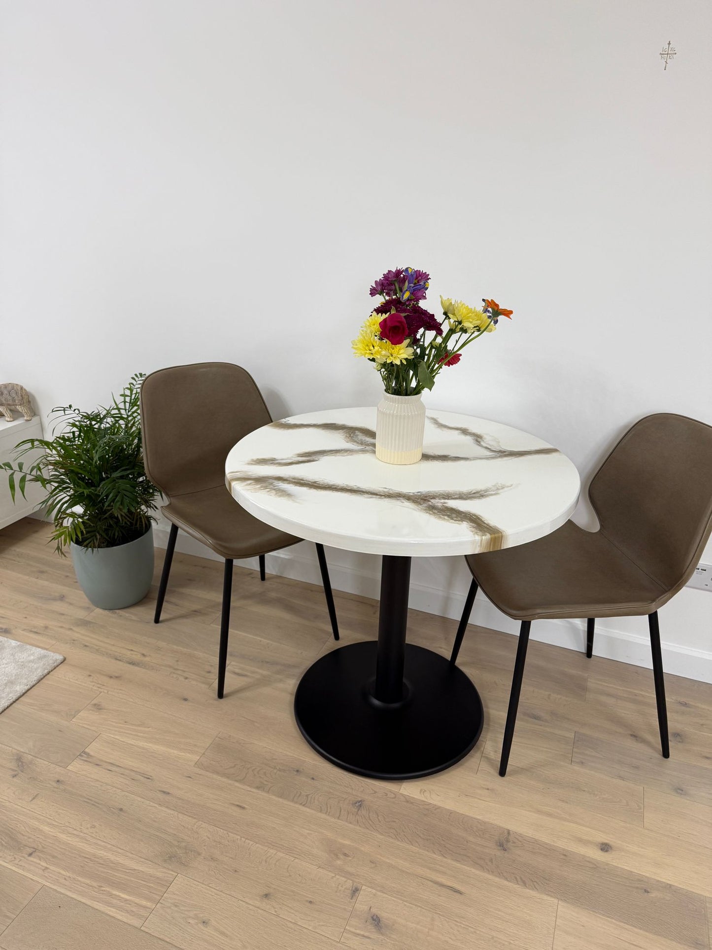 Handmade round epoxy resin dining table with 3.6 cm thick top and cast iron pedestal base – made to order in the UK.