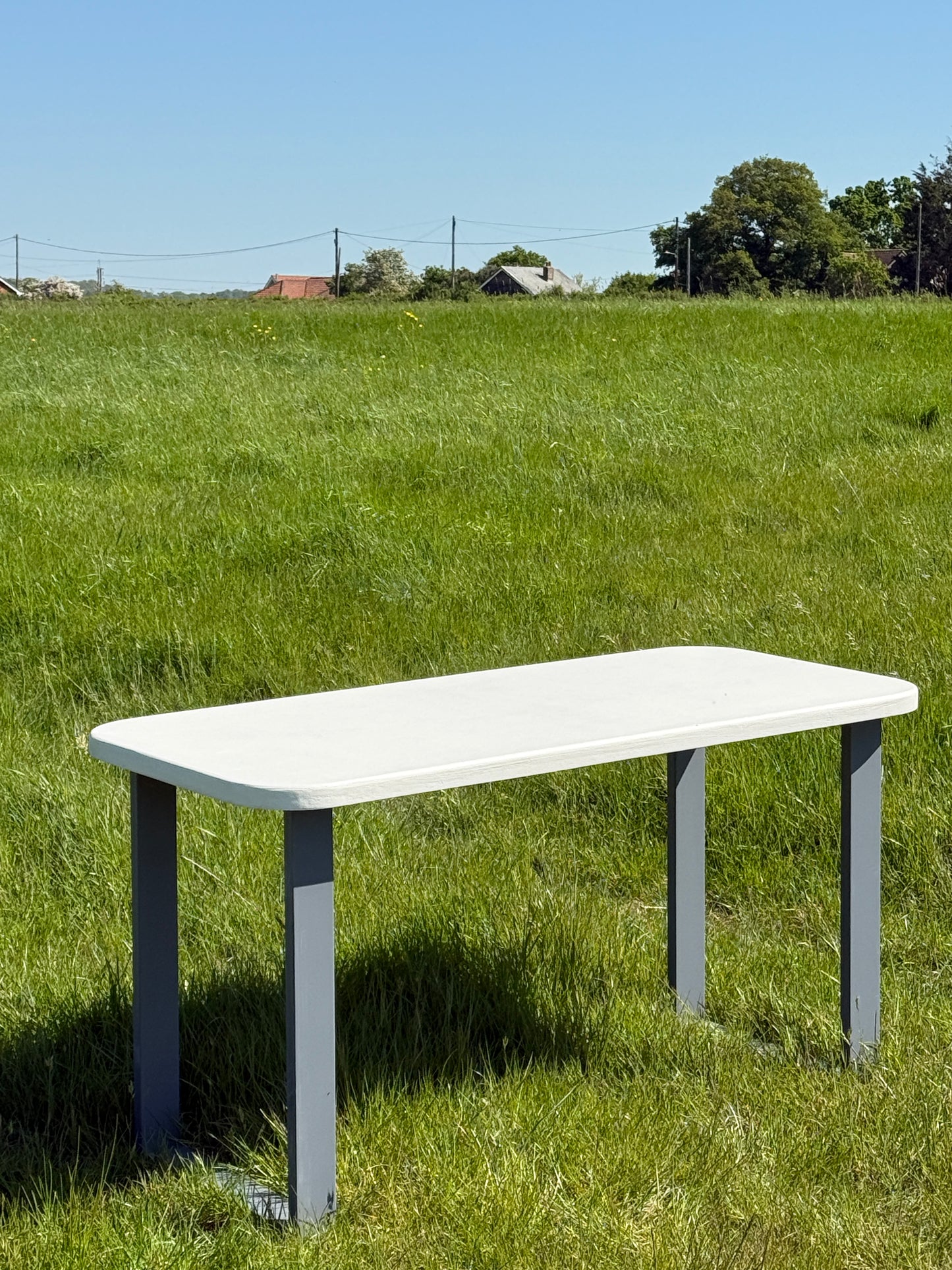 Handmade outdoor microcement dining table with white concrete-style top and matching benches – made to order in the UK, ideal for patios and terraces.