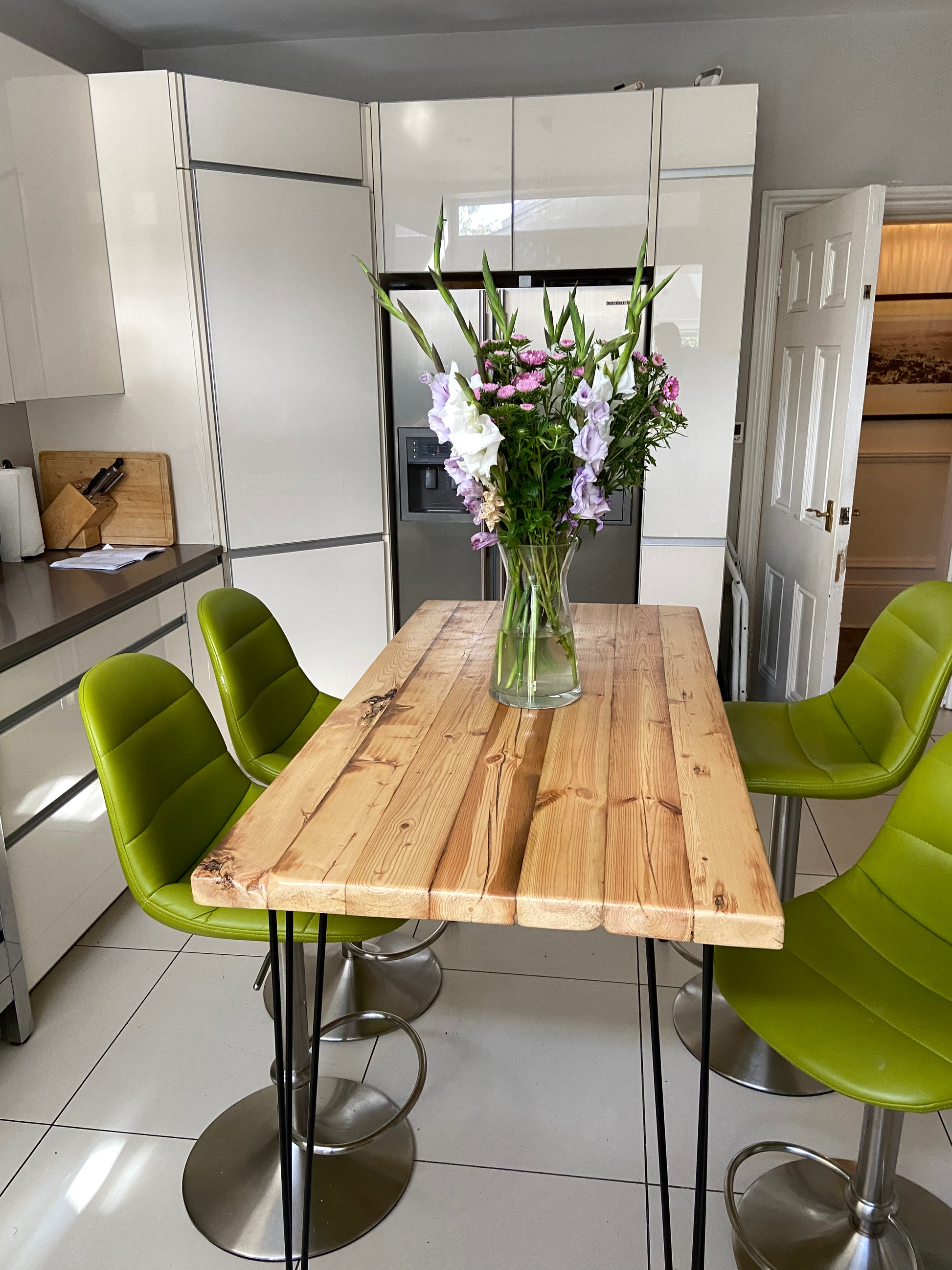 Handcrafted reclaimed wood breakfast bar made from aged joists, featuring natural imperfections, a smooth wax finish, and 90cm high industrial metal legs