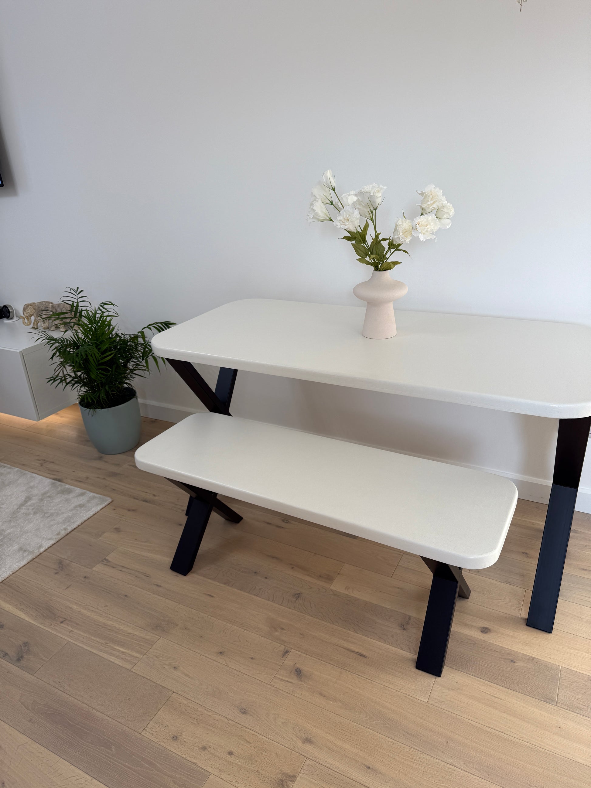 Handmade microcement dining table with white concrete-style top and matching benches, black metal legs – made to order in the UK.
