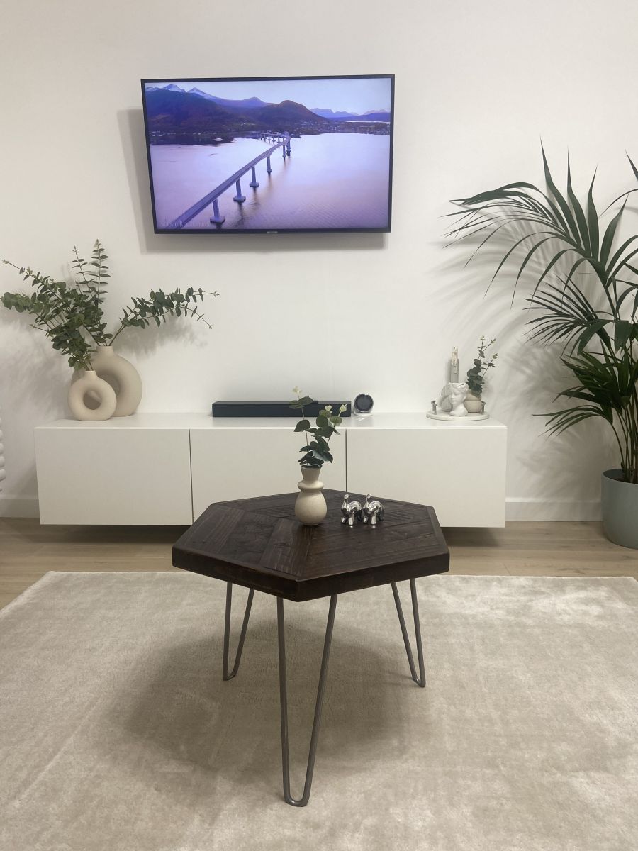 Hexagonal reclaimed wood coffee table with raw steel hairpin legs, rustic handcrafted design with eco-friendly wax finish