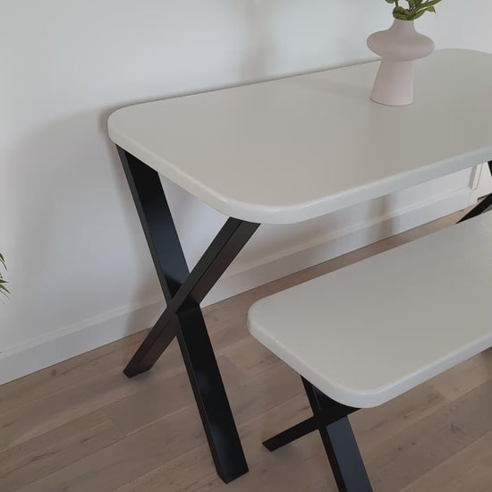 Handmade microcement dining table with white concrete-style top and matching benches, black metal legs – made to order in the UK.