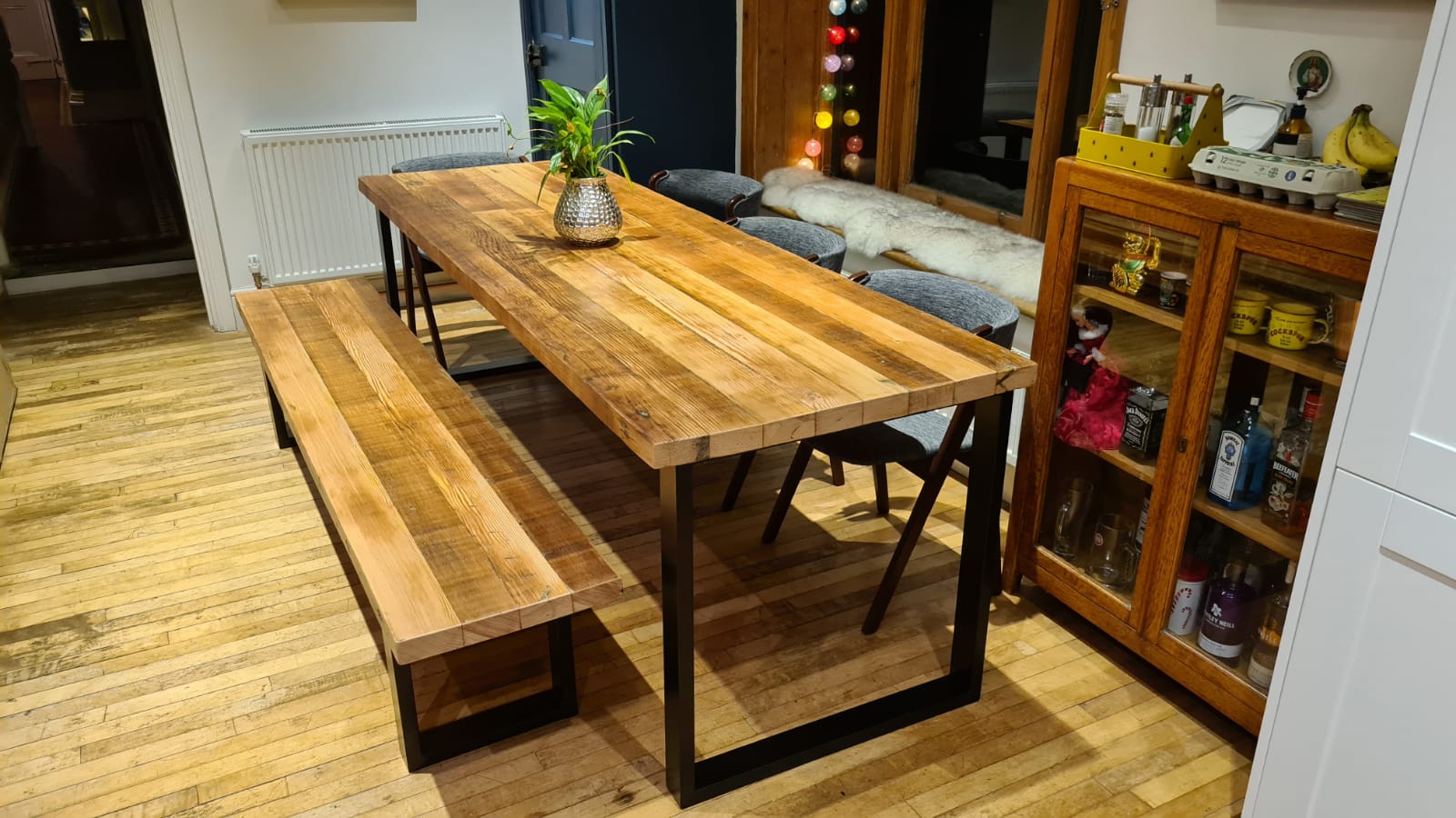 Reclaimed wood dining table with matching benches tucked underneath – rustic industrial style furniture set