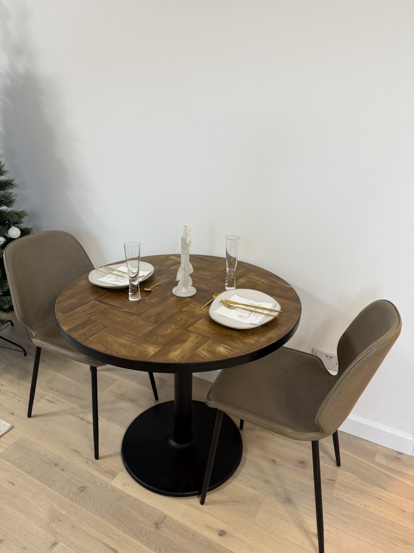 Handmade round reclaimed wood dining table with double herringbone pattern, smooth sanded top, and natural wax finish – rustic and elegant UK craftsmanship