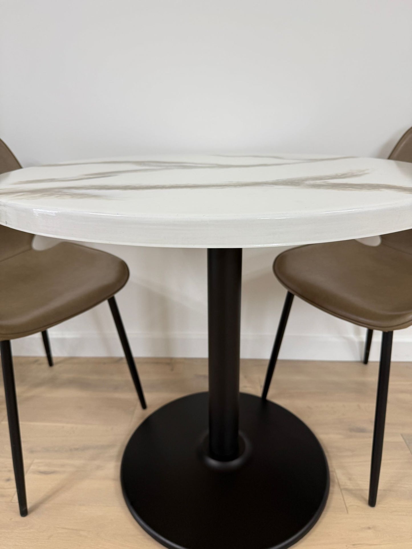 Handmade round epoxy resin dining table with 3.6 cm thick top and cast iron pedestal base – made to order in the UK.