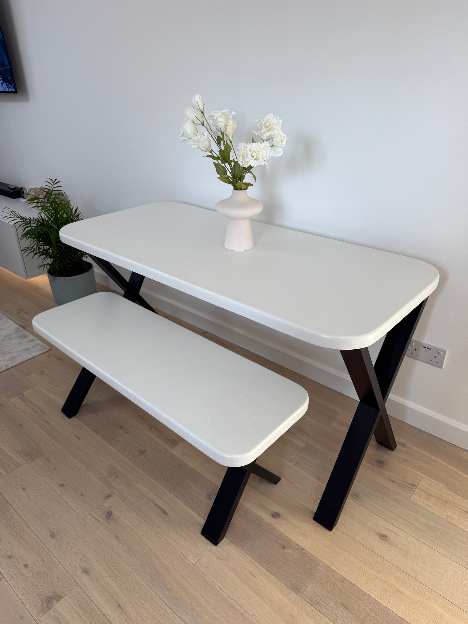 Handmade microcement dining table with white concrete-style top and matching benches, black metal legs – made to order in the UK.